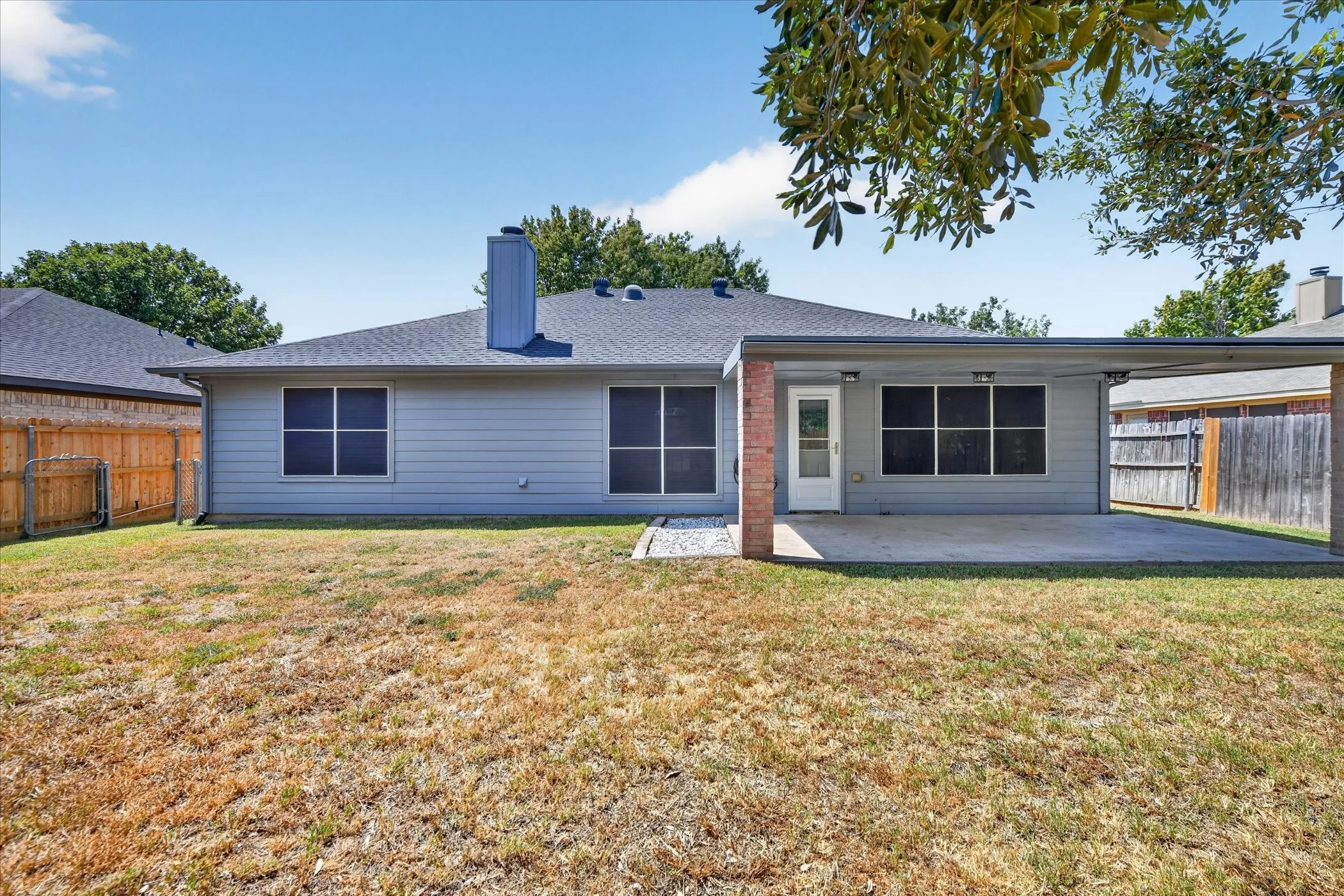 Private backyard featuring a covered patio and a wood privacy fence