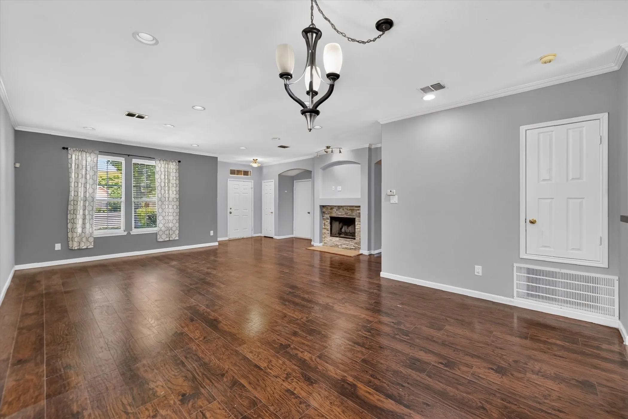 Wood-finish flooring throughout, recessed lighting, and a stone-faced fireplace