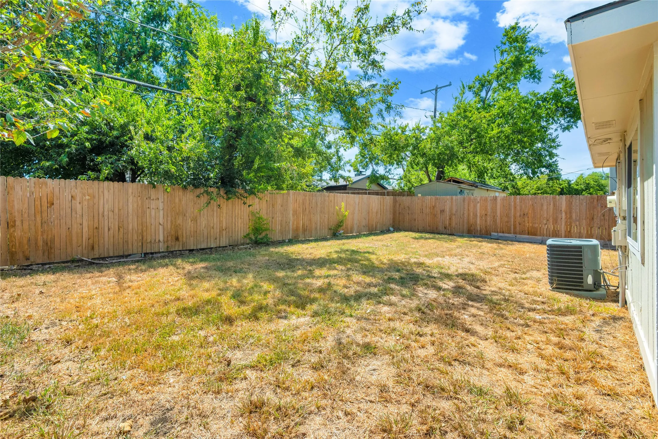 Expansive backyard enclosed by a wood privacy fence