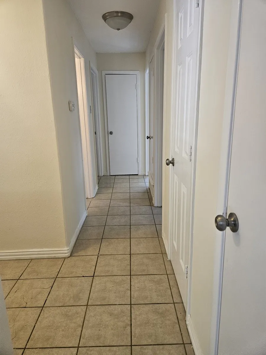 Neutral-toned tile flooring throughout the hallway