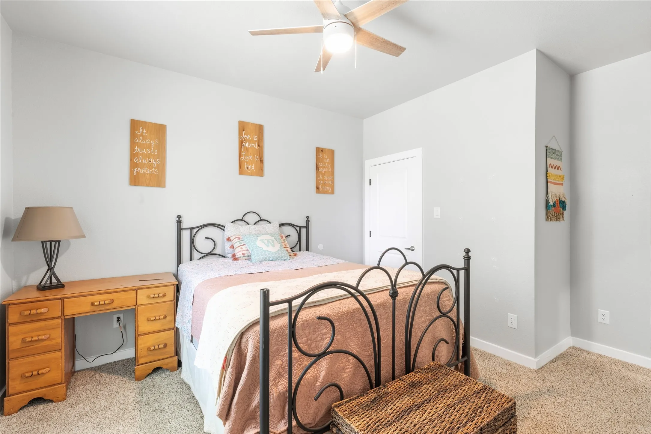 Neutral wall color with carpeting and a ceiling fan