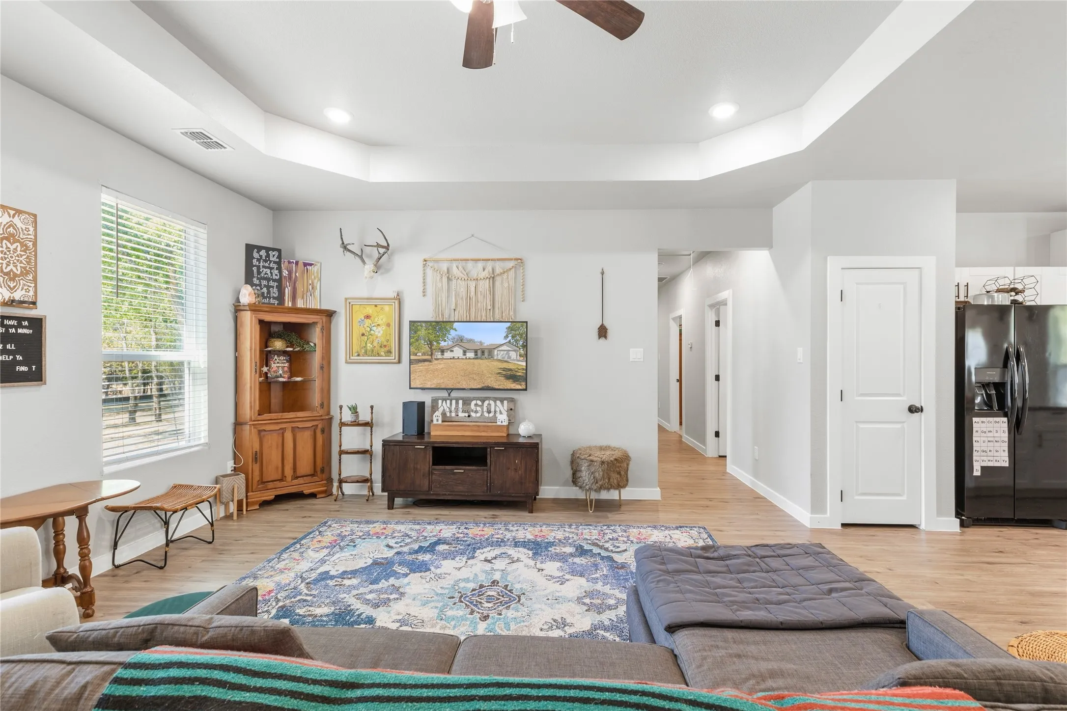 Tray ceiling with recessed lighting, wood-finish flooring, and white interior doors