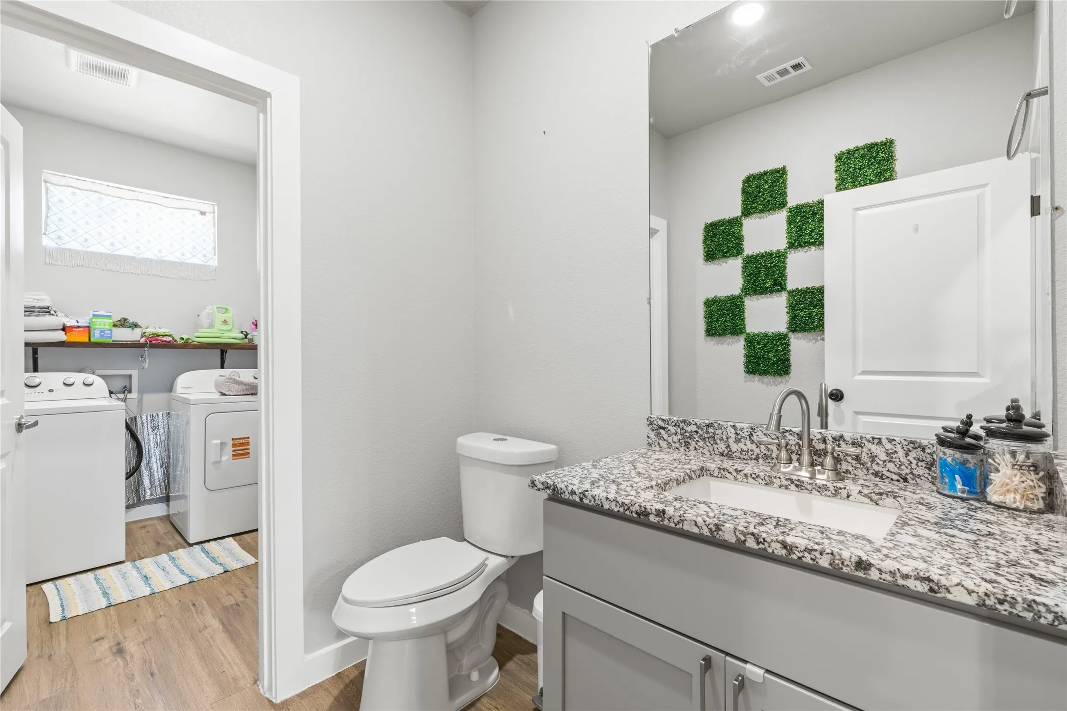 Granite-style countertop with an integrated sink, brushed nickel faucet, and gray vanity cabinetry