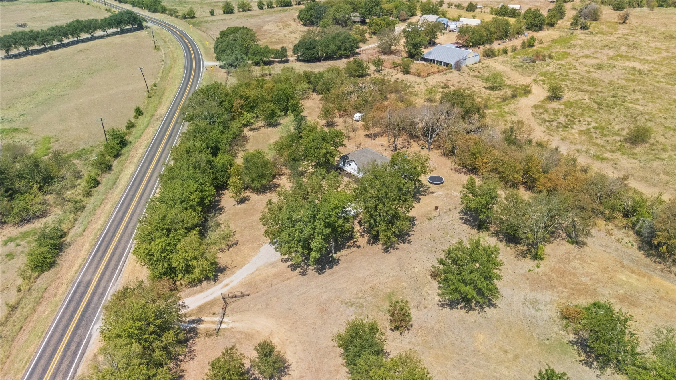 Scenic rural acreage featuring mature oak trees, natural water features, and expansive pastureland