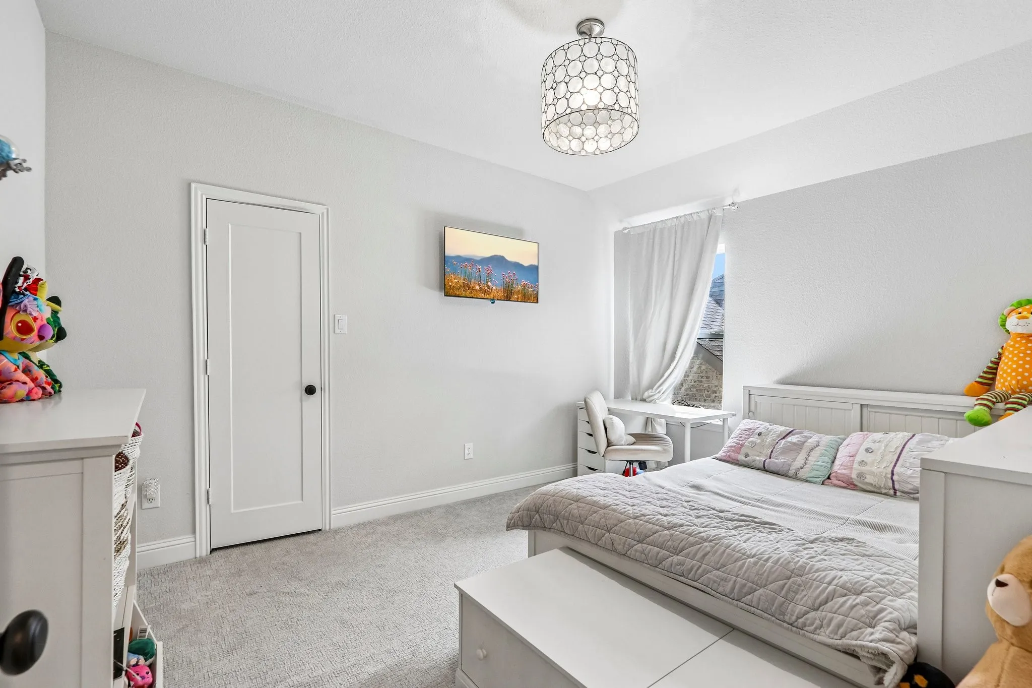 Wall-mounted television, recessed window with white drapery, and a contemporary ceiling light fixture
