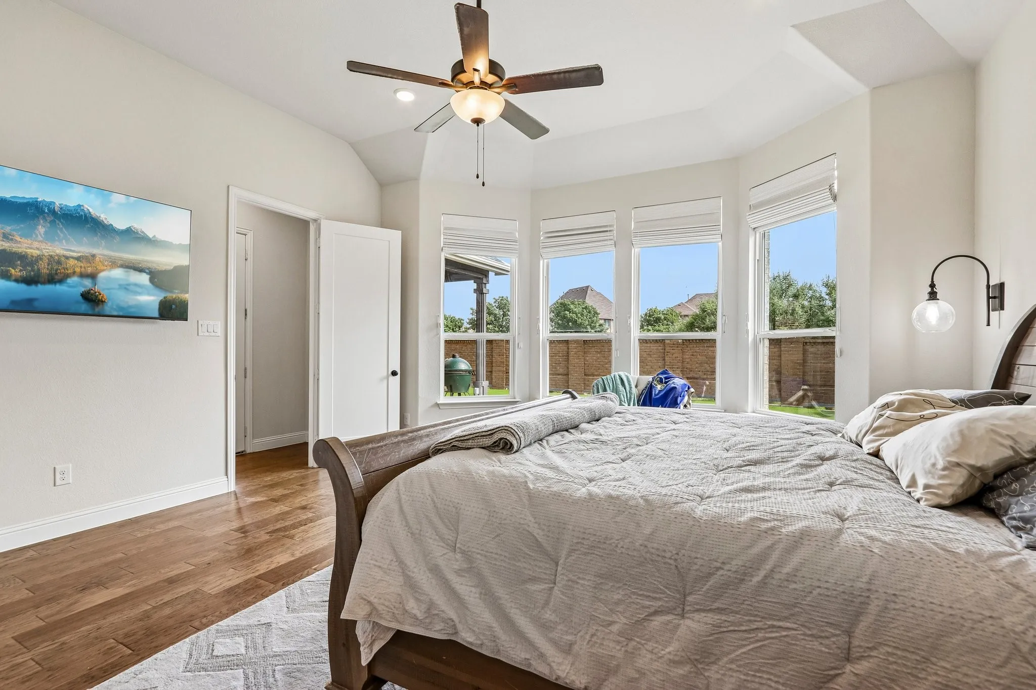 Wood-finish flooring, vaulted ceiling, and a ceiling fan with integrated lighting