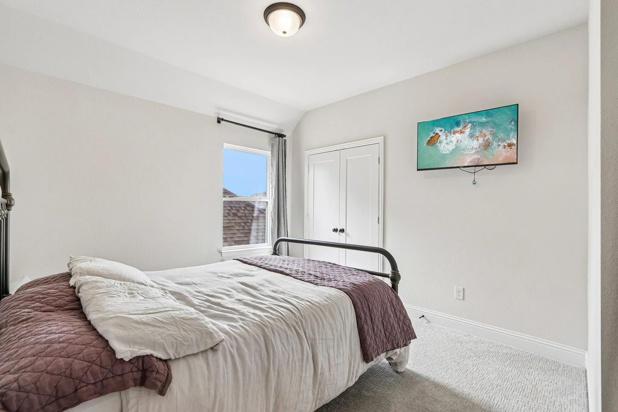 Recessed window with dark curtain rod, ceiling-mounted light fixture, and carpeted flooring