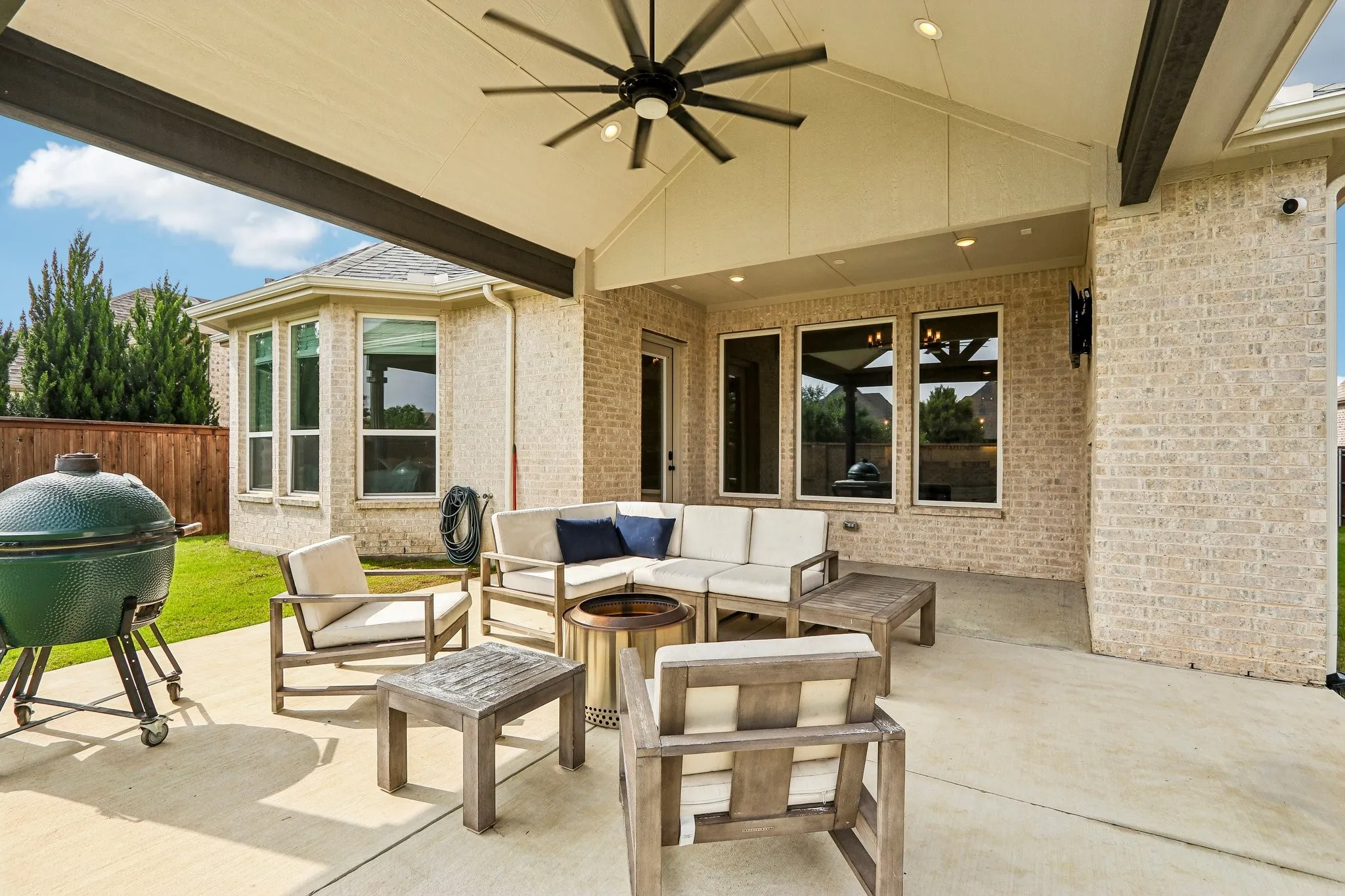 Covered outdoor patio with a ceiling fan, recessed lighting, and a brick exterior