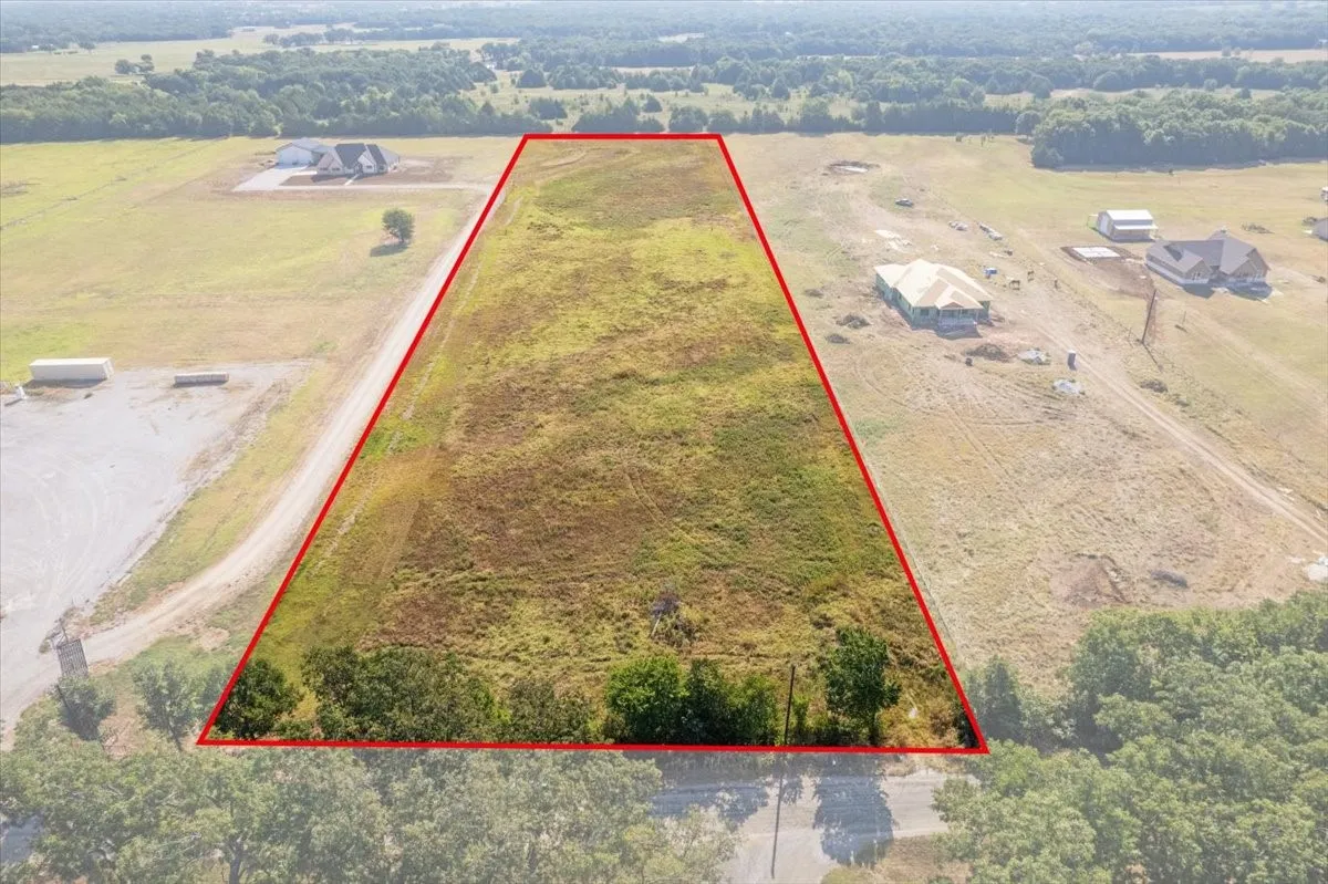 Expansive undeveloped lot with existing road access and surrounding mature trees