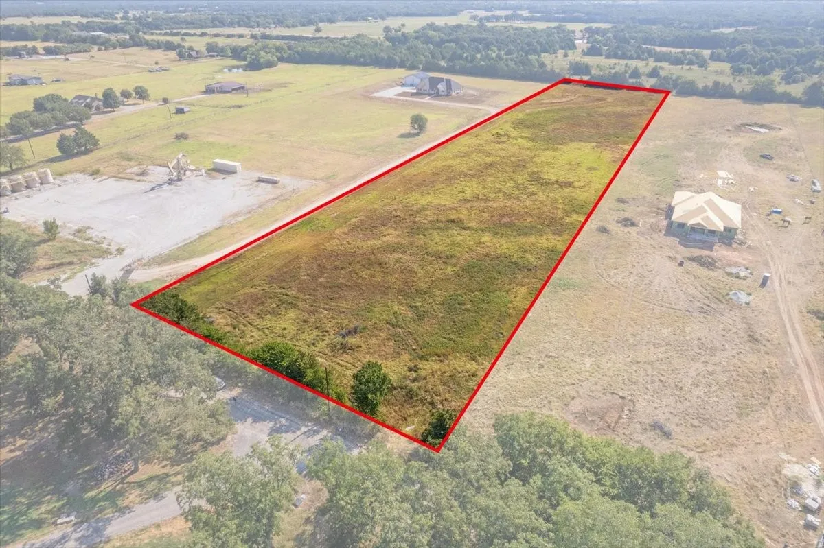Expansive land parcel featuring open fields and partial tree coverage