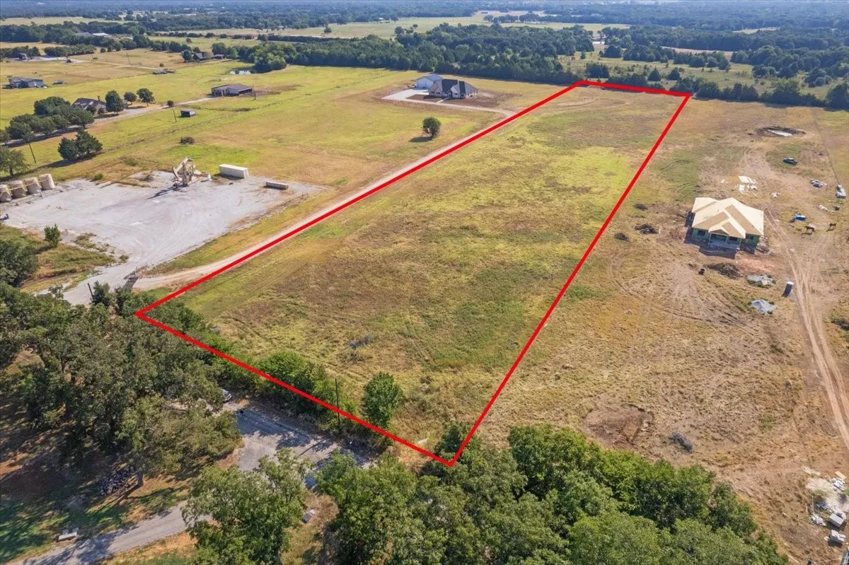 Expansive undeveloped lot with existing road access and surrounding mature trees