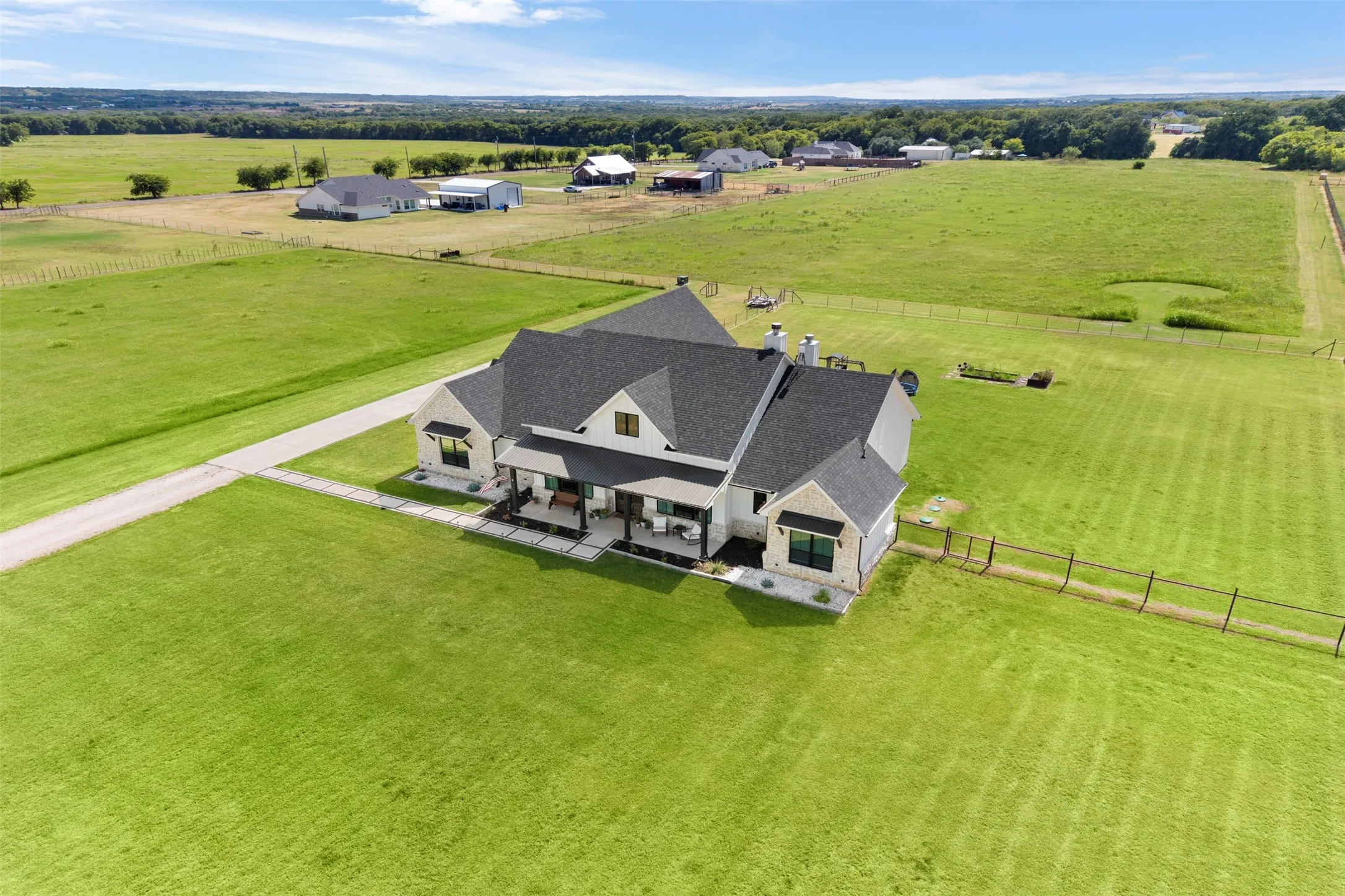 Modern farmhouse exterior with dark-pitched roofing and light-toned siding