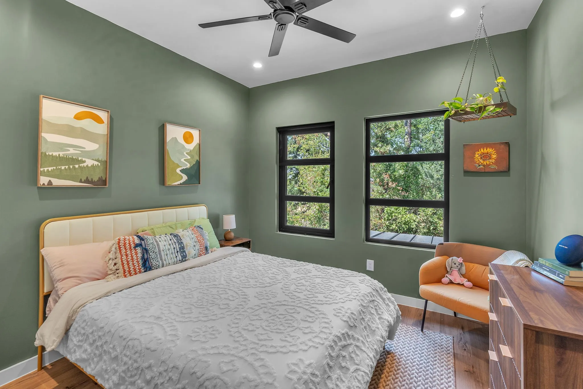 Two large windows, recessed ceiling lighting, a ceiling fan, wood-finish flooring, and painted walls