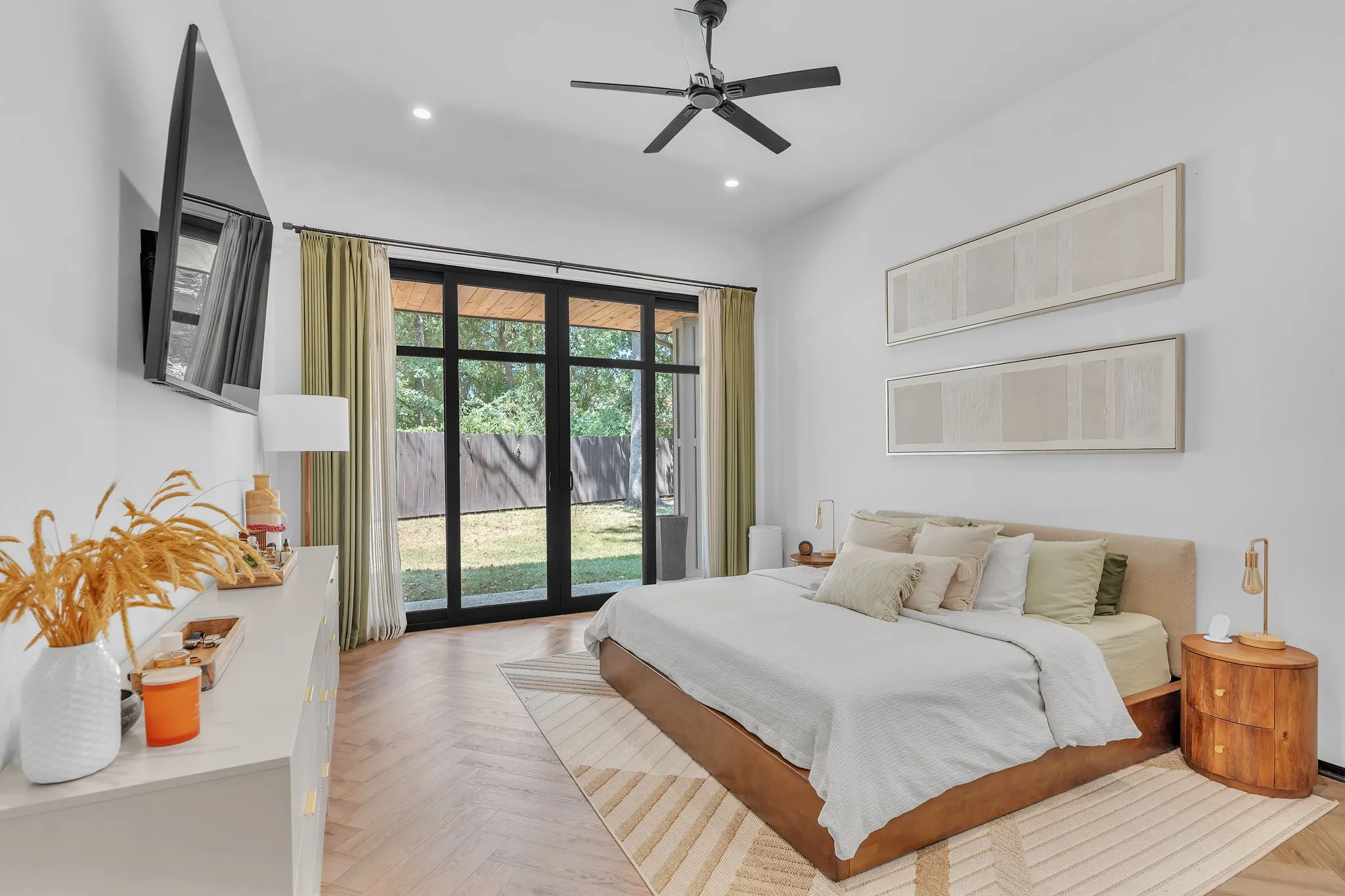 Herringbone wood-finish flooring, vaulted ceiling, recessed lighting, modern ceiling fan, and black-framed glass doors