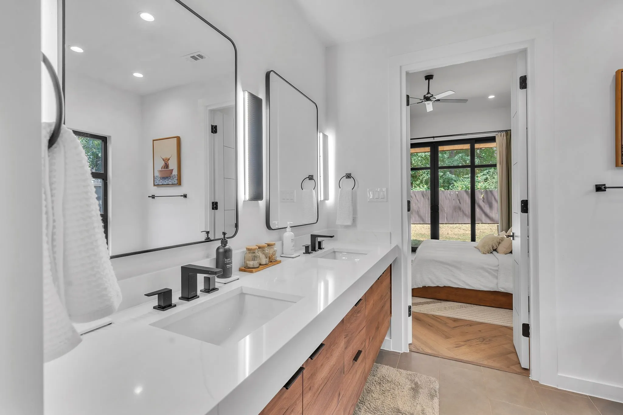 Dual rectangular undermount sinks set in a white countertop with matte black faucets