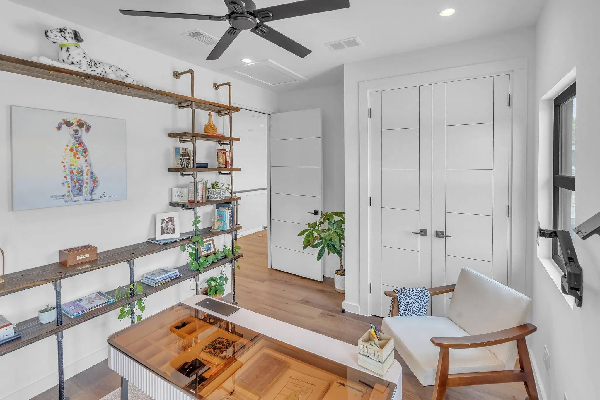 Ceiling fan with matte black finish, wood-finish flooring, built-in shelving, paneled double doors, and recessed lighting