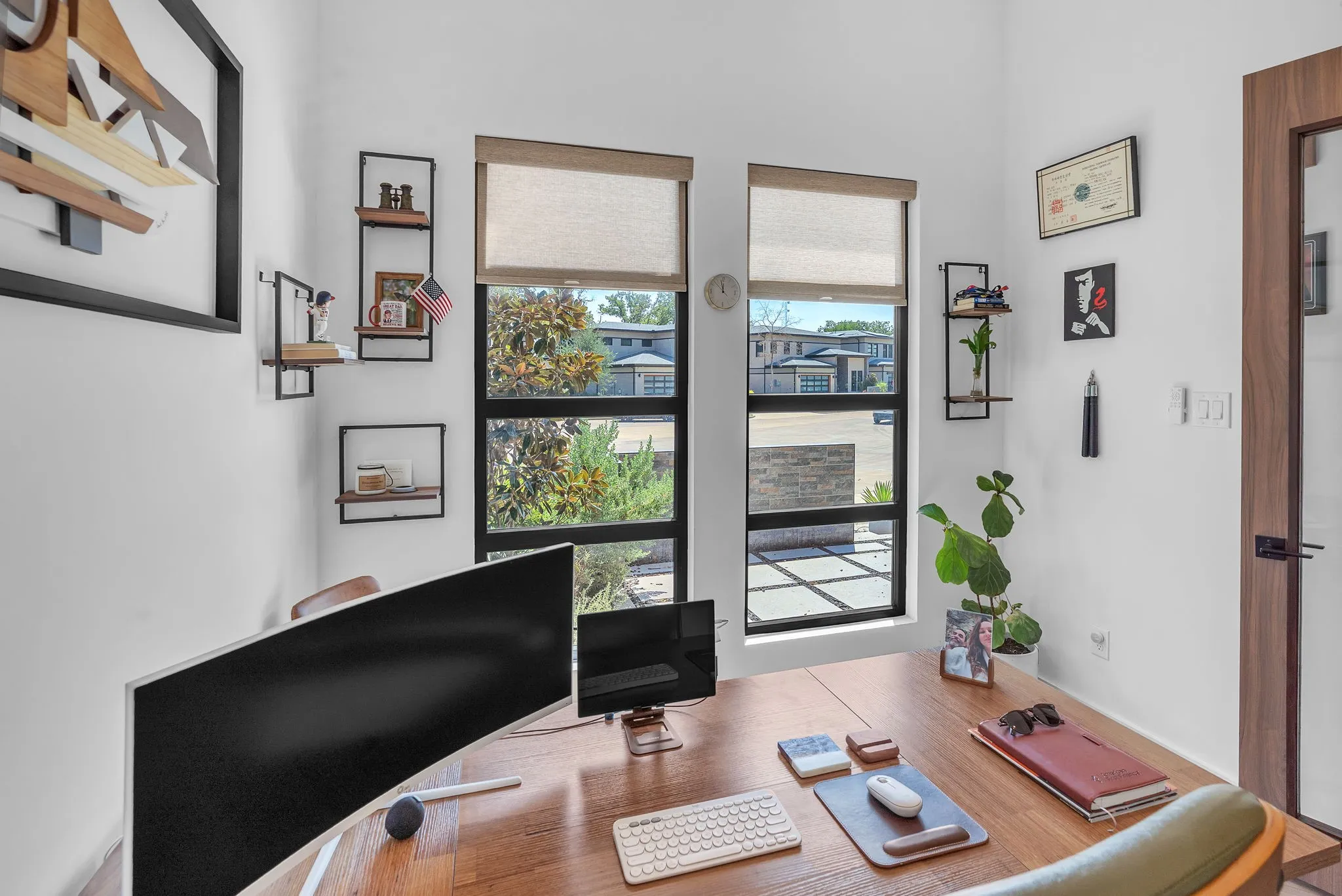 Spacious interior with white walls, two large multi-pane windows, and a wood-finish door