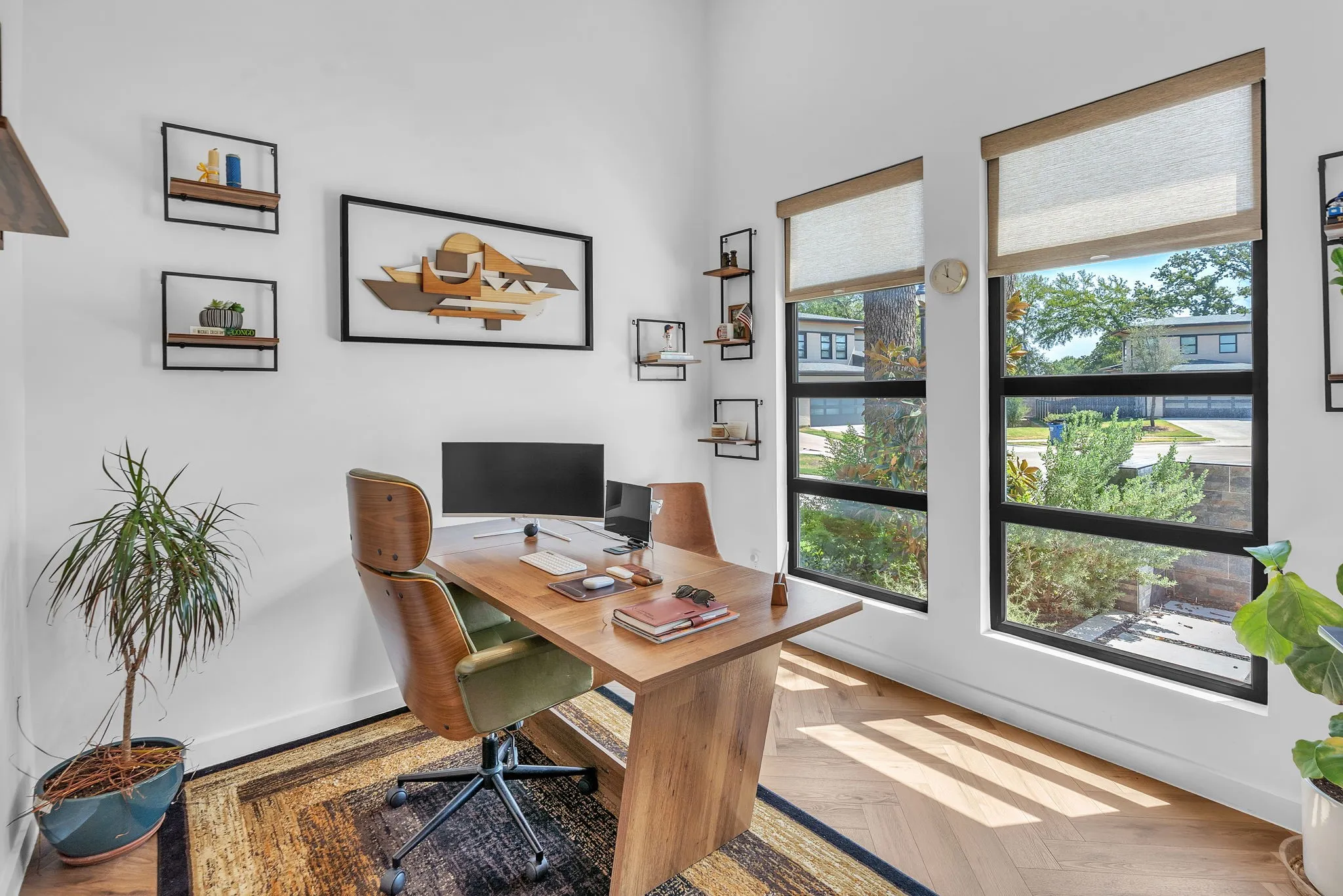 Expansive windows with roller shades, light wood-finish flooring, and white walls