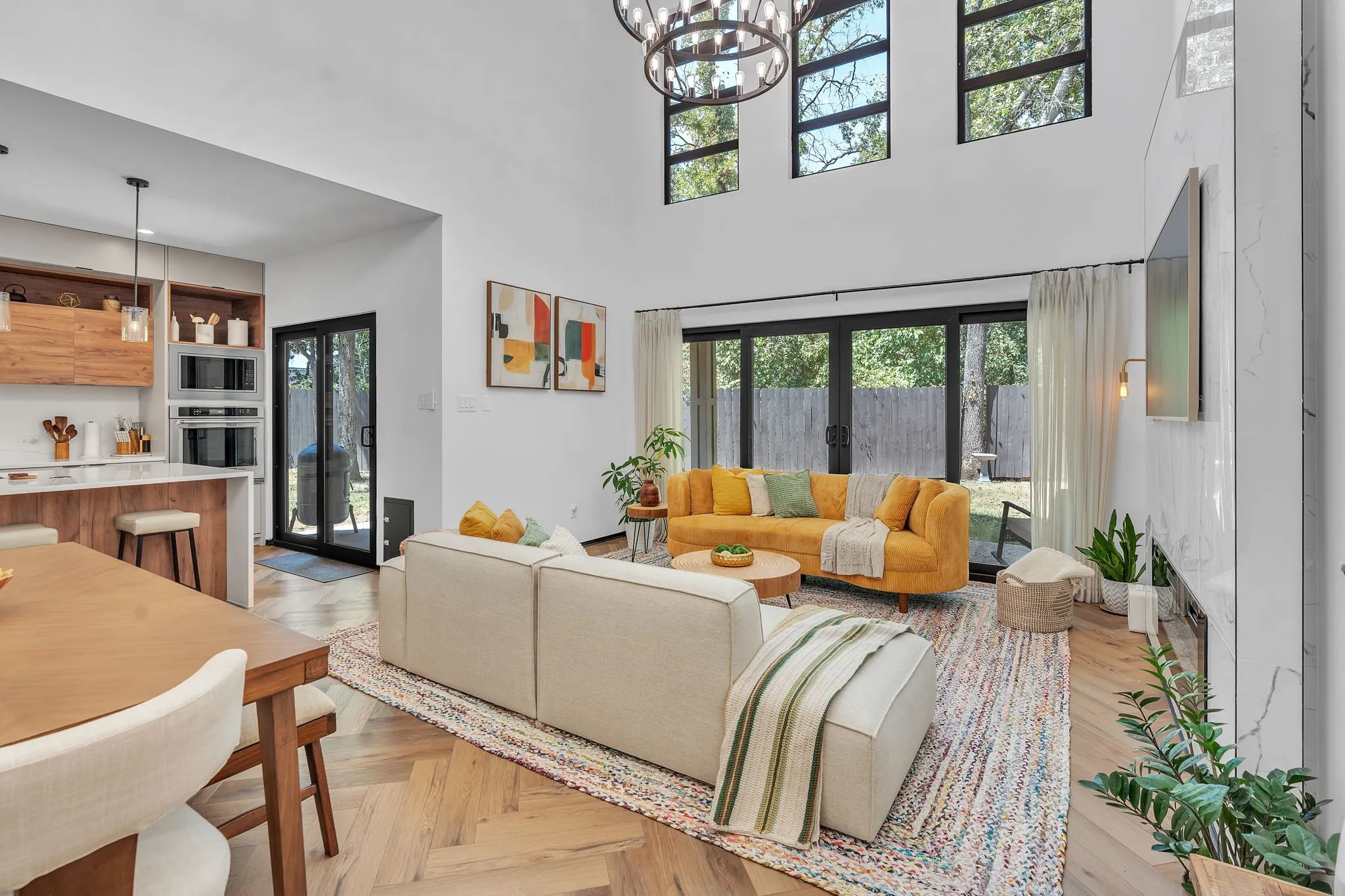 Spacious living area with high ceilings, recessed lighting, and herringbone wood-finish flooring
