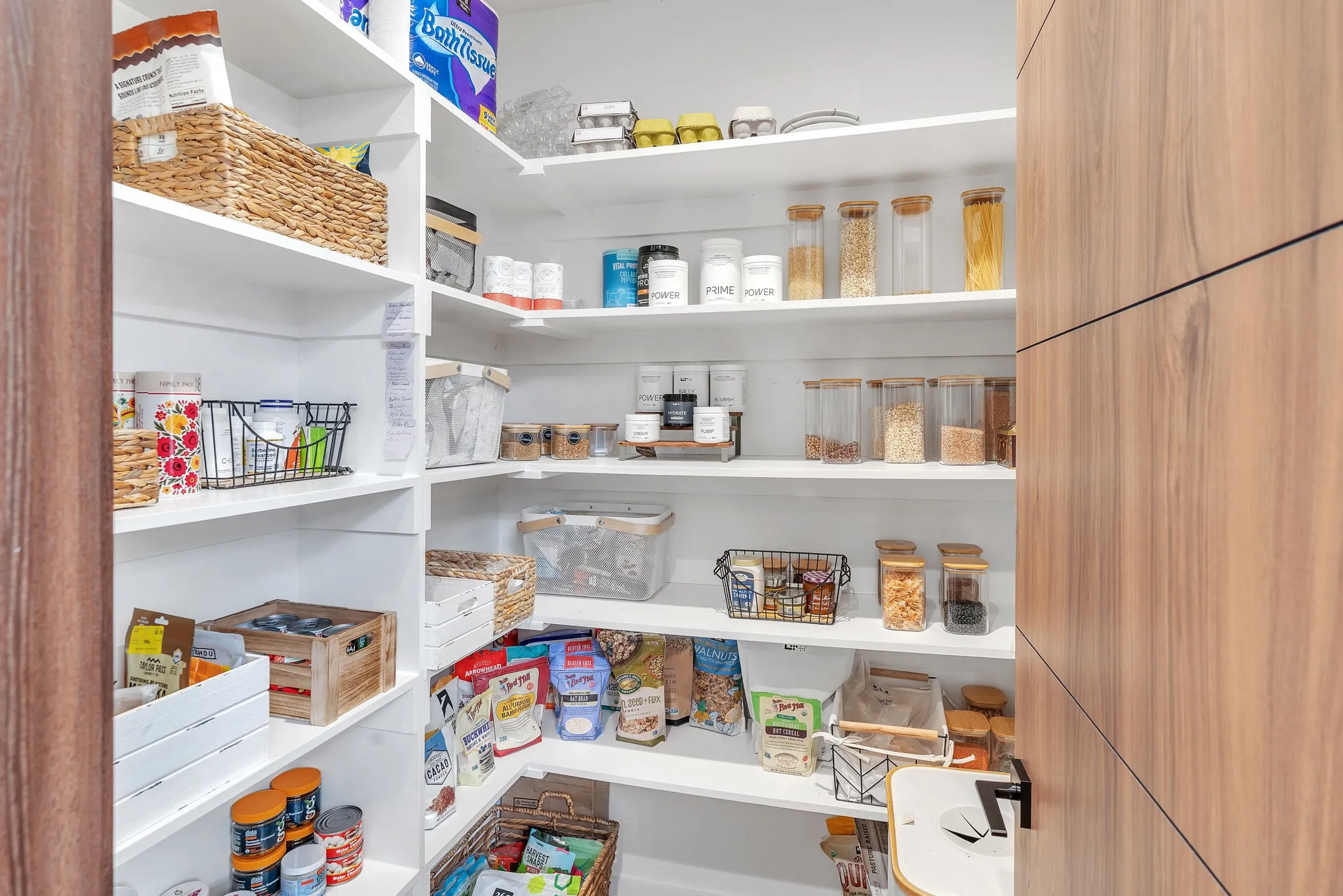 Custom built-in shelving, white shelving, and a wood-finish door