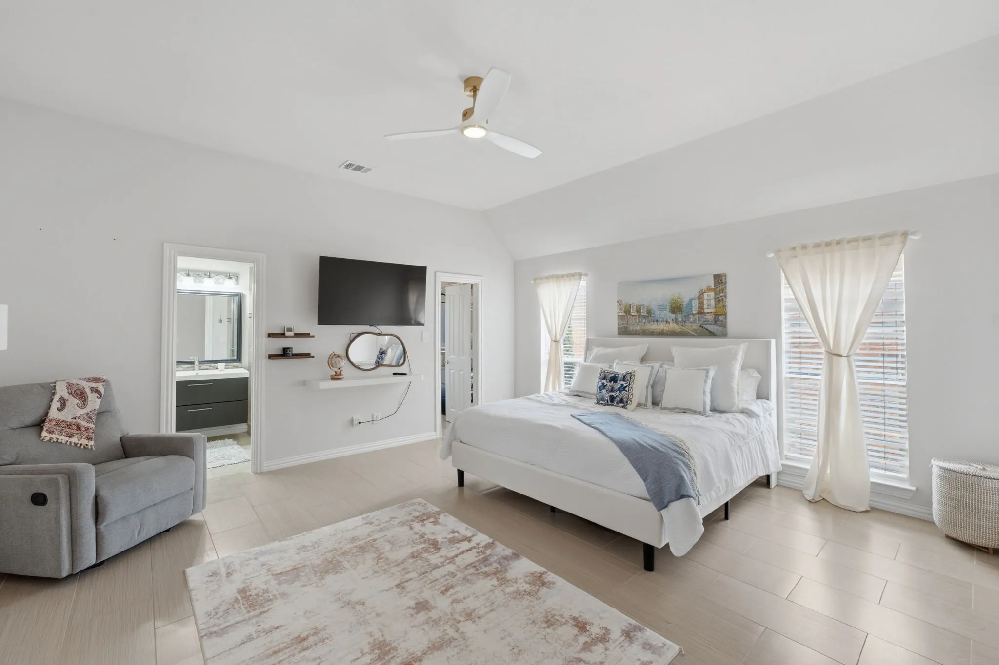 Vaulted ceiling with a ceiling fan, light-toned tile flooring, and two windows with blinds