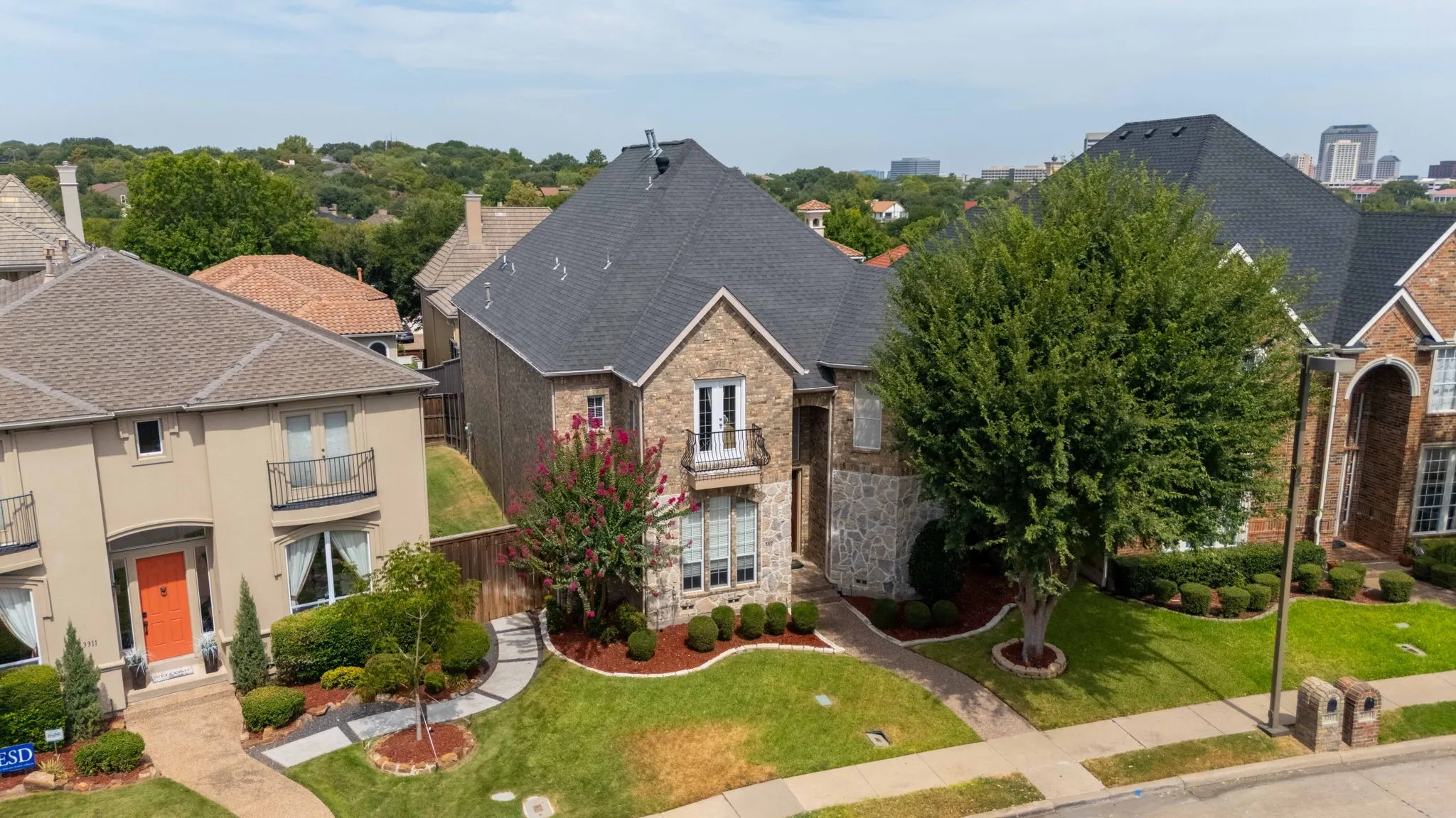 Brick and stone veneer exterior with a dark shingle roof