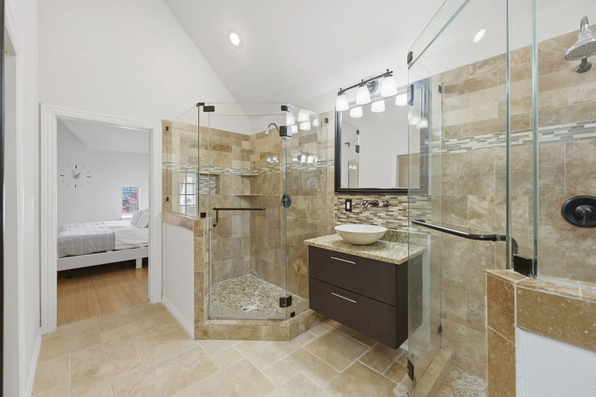 Glass-enclosed shower with stone tile surround, mosaic accent tile, and a rainfall shower head