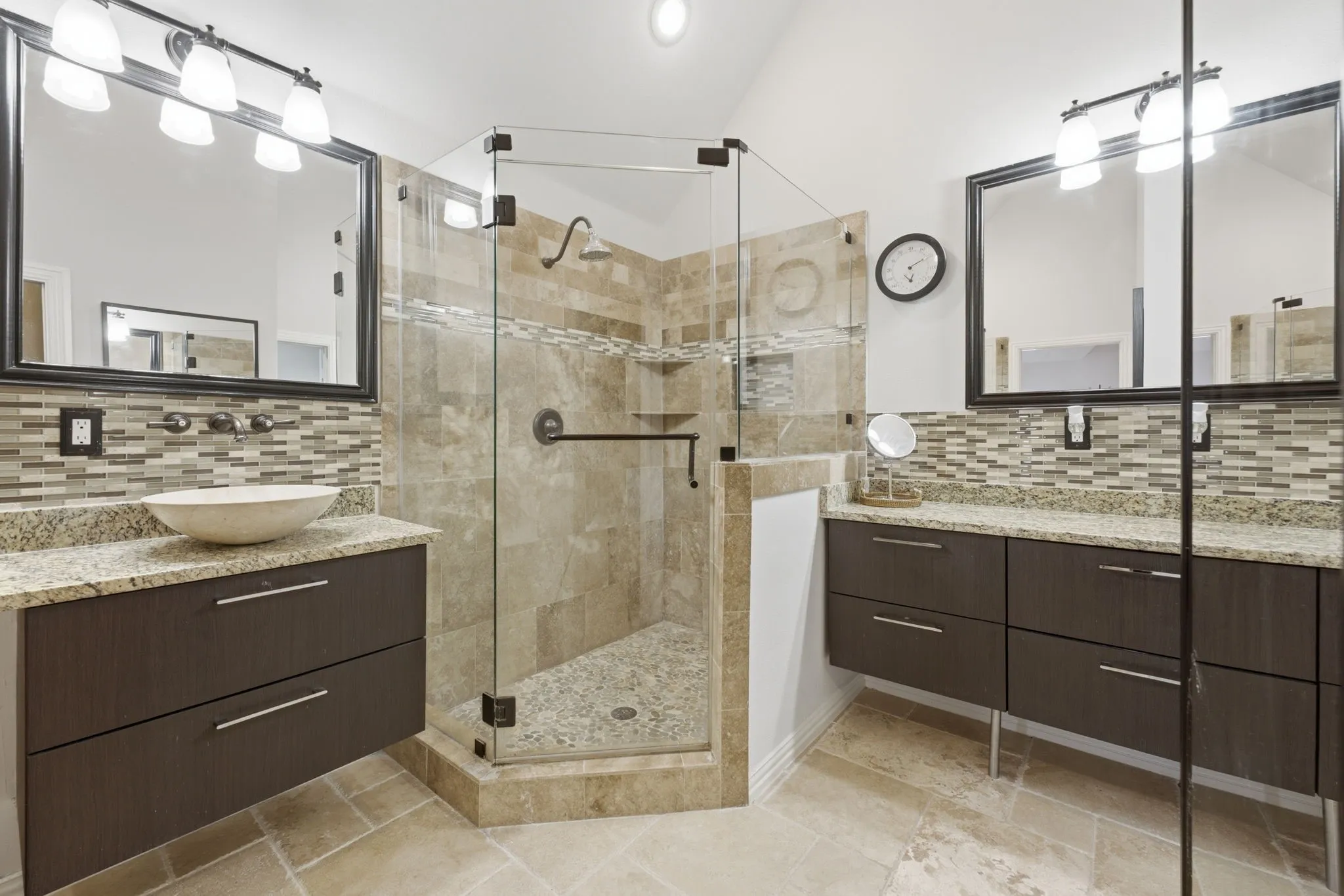 Dual vanities with stone countertops, vessel sink, and mosaic tile backsplash
