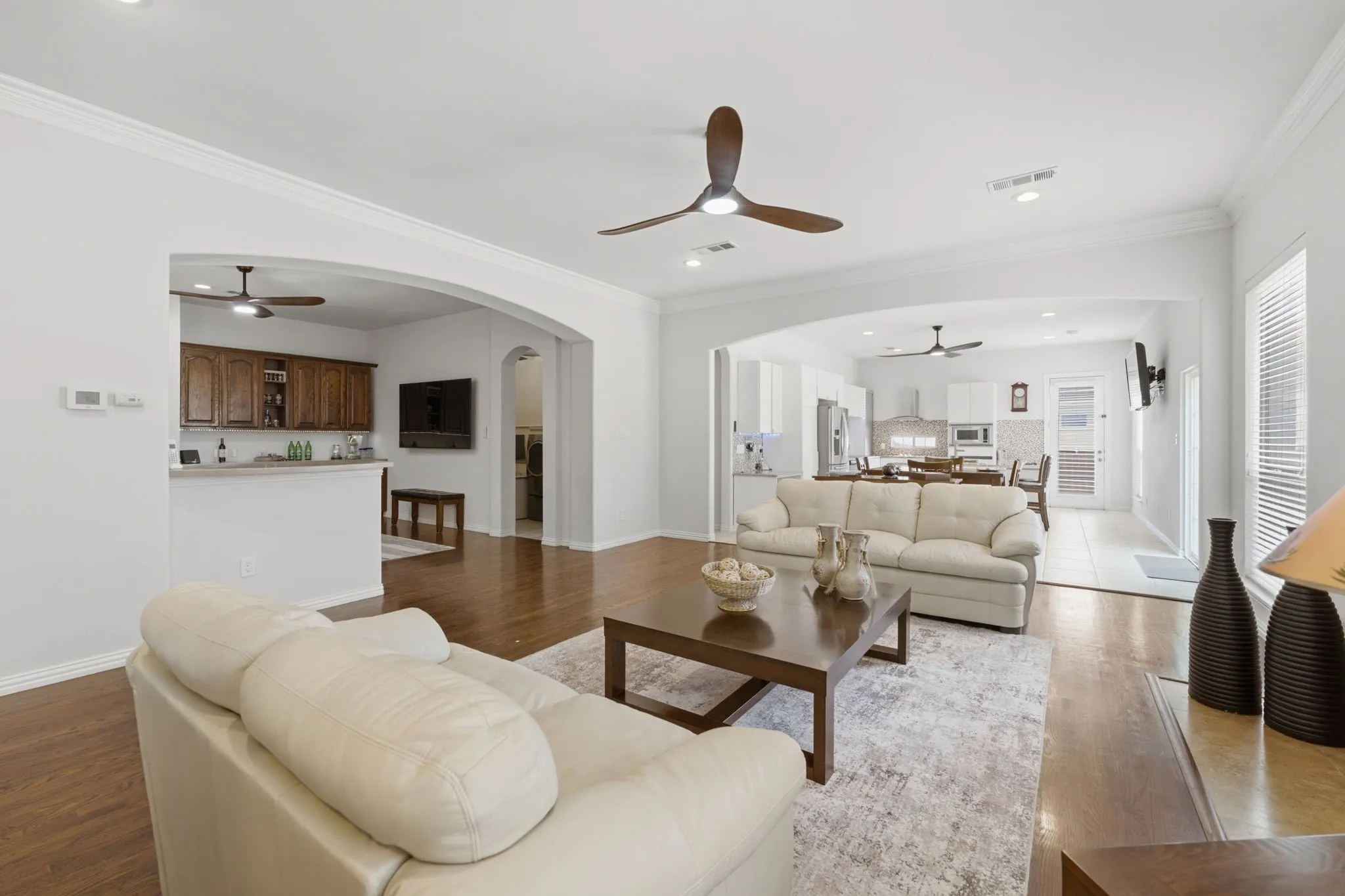 Hardwood flooring, recessed lighting, crown molding, arched doorways, and ceiling fans