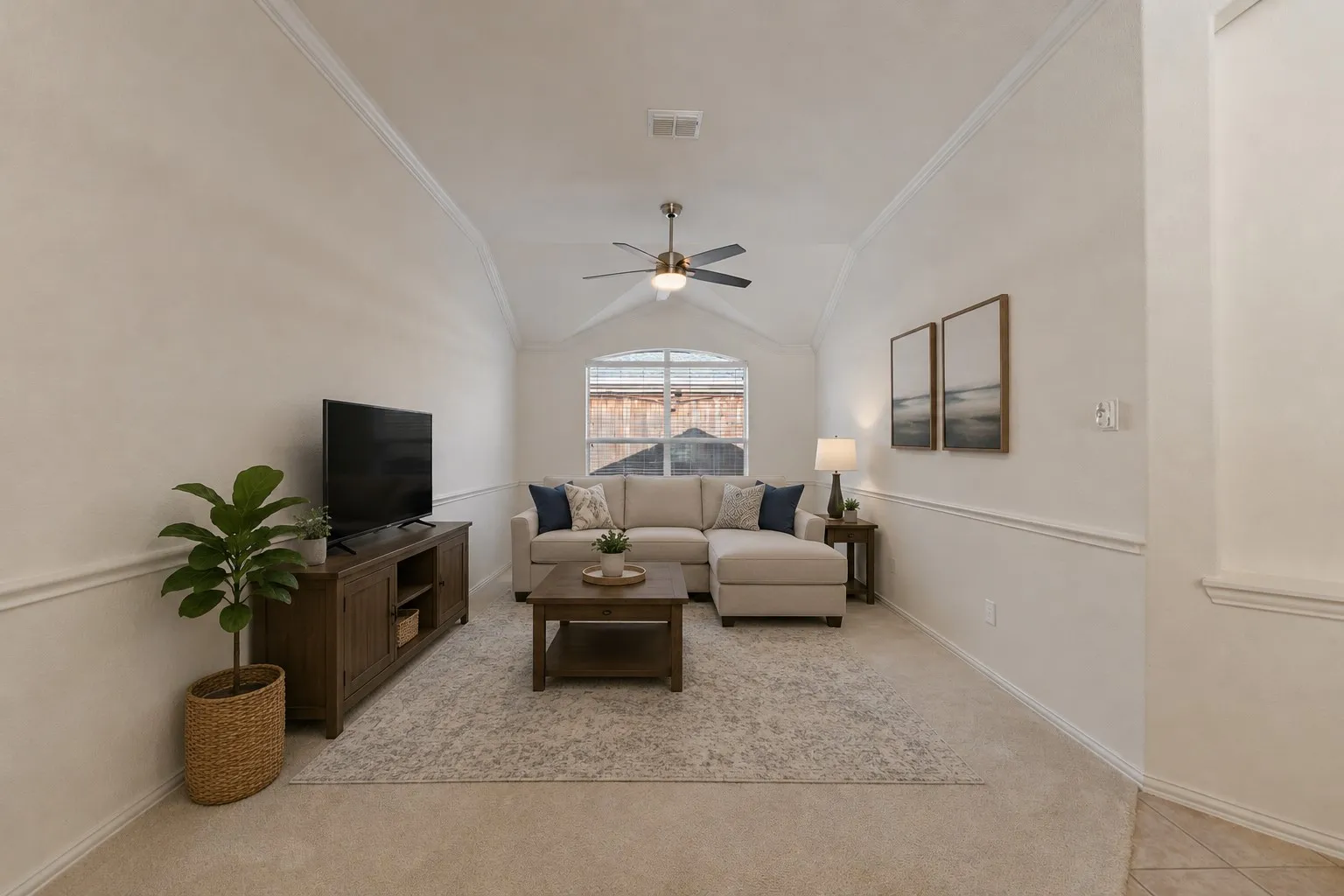 Vaulted ceiling with a ceiling fan, wall molding details, and a large window