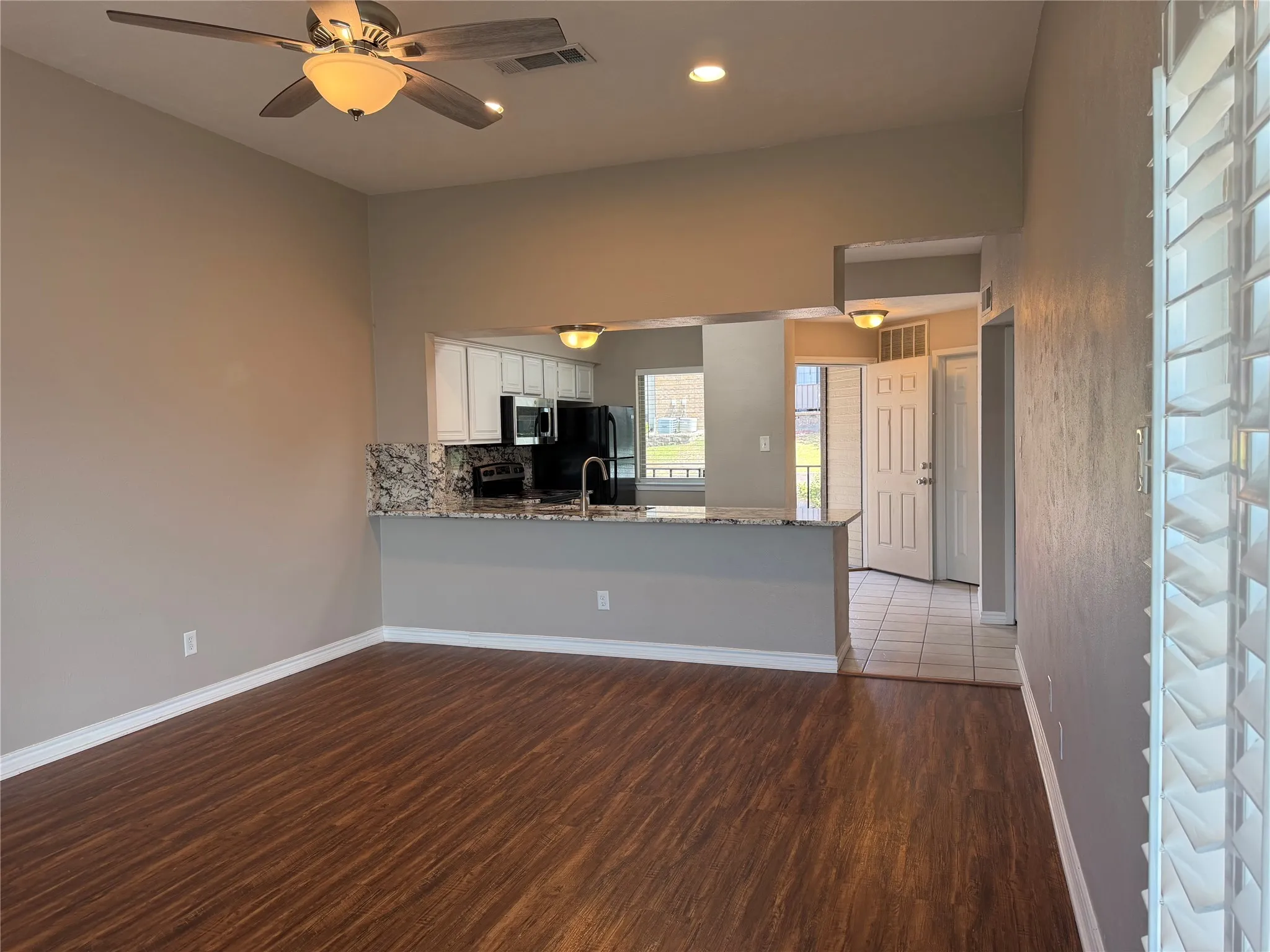 Entertaining Will Truly Be a Dream in the Large Open Living Area Highlighted by a Massive Granite Breakfast Bar and Elegant Plantation Shutters