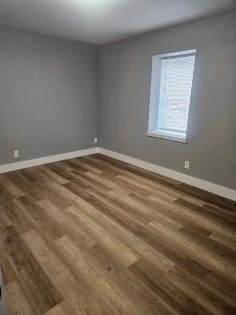 Wood-finish flooring, neutral wall tones, and a window with blinds
