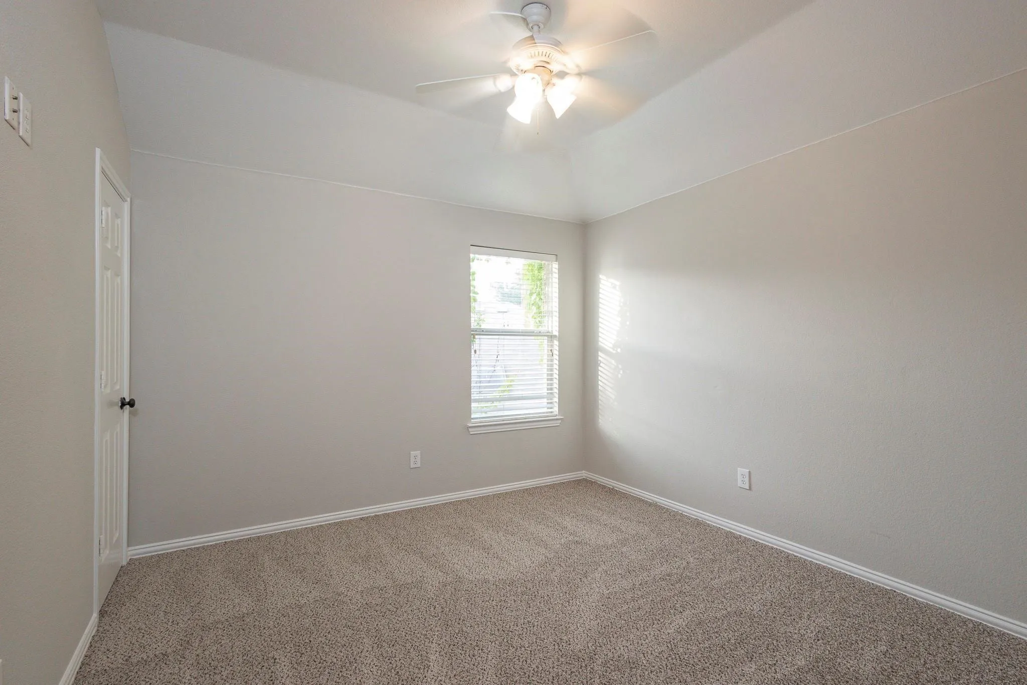 Vaulted ceiling with ceiling fan, neutral wall paint, window with blinds, panel door, and carpet flooring