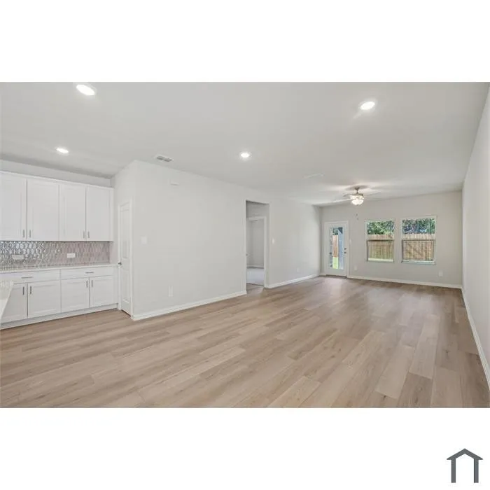Wood-finish flooring, recessed lighting, white cabinetry, a tiled backsplash, and a ceiling fan