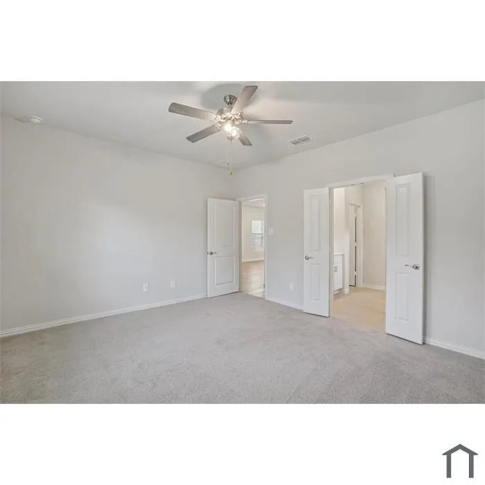Spacious room featuring light gray carpeting, a ceiling fan, and white painted walls