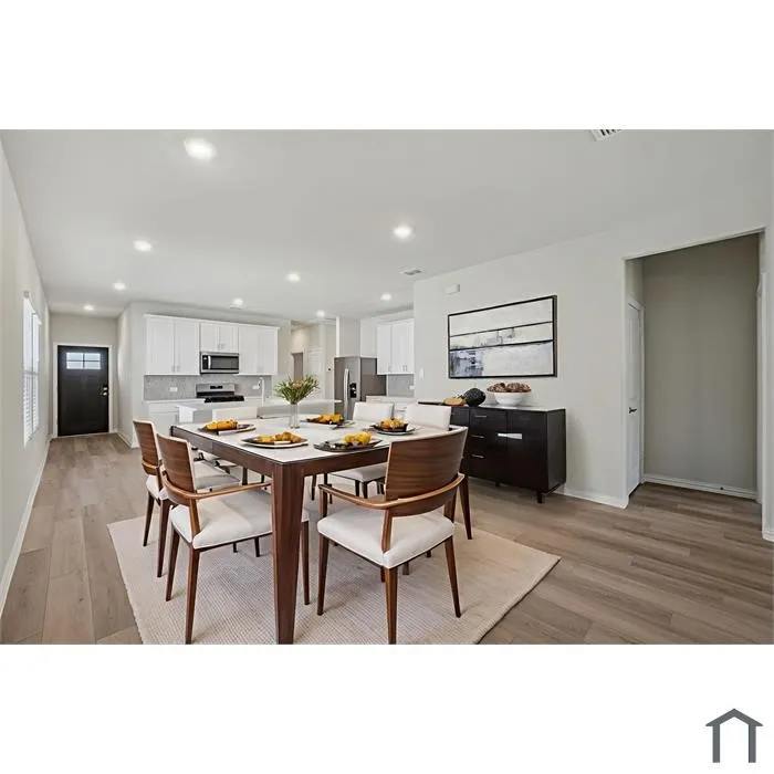 Open-concept kitchen and dining area featuring recessed lighting, wood-finish flooring, and white cabinetry