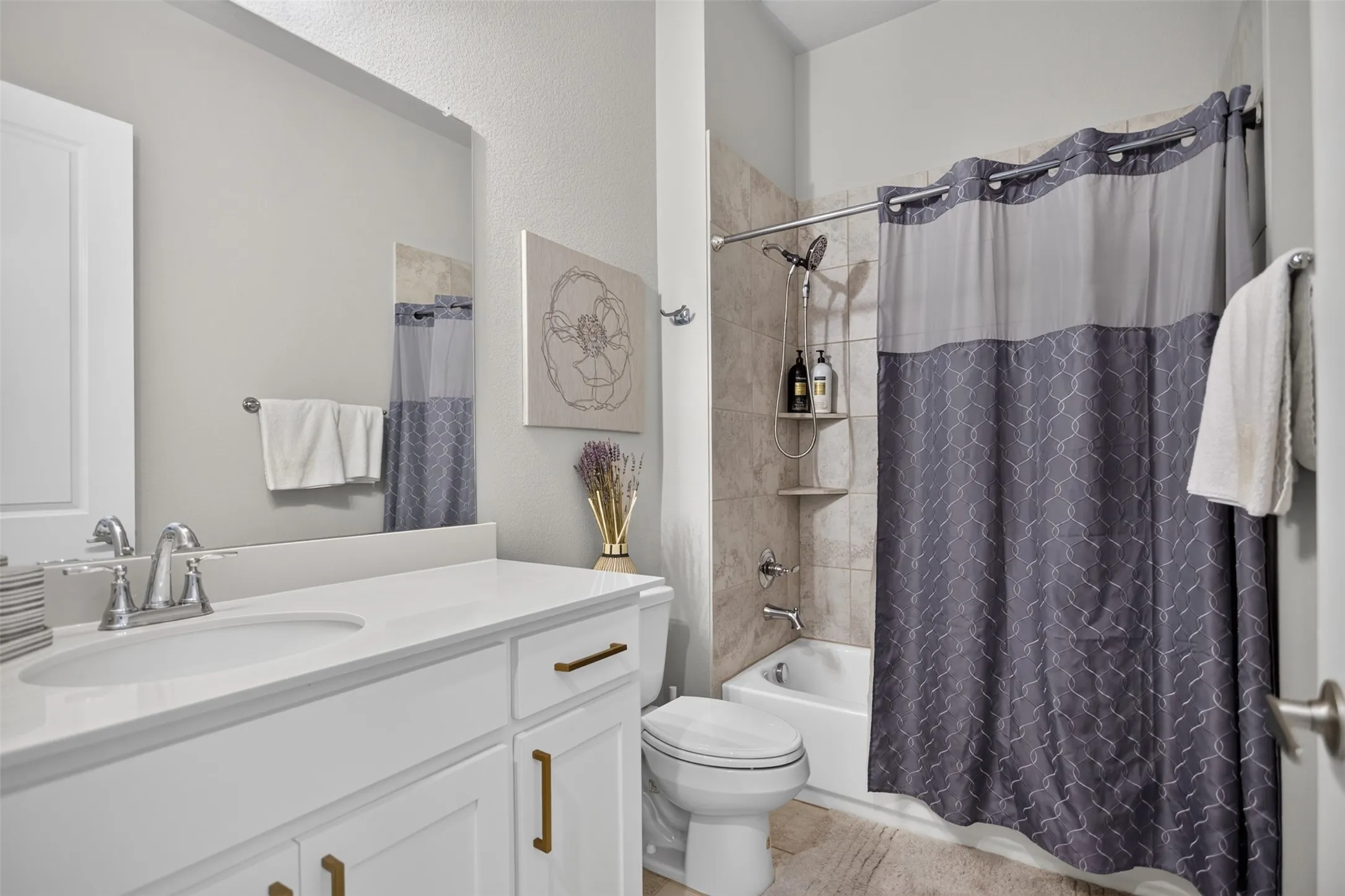 White vanity with brass hardware and an integrated sink