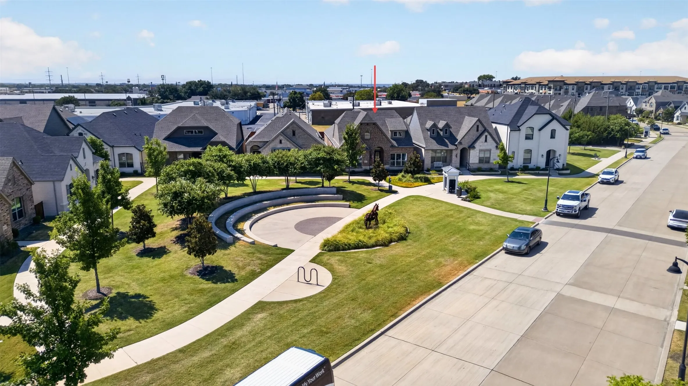 Expansive green space featuring a concrete amphitheater and winding paved pathways