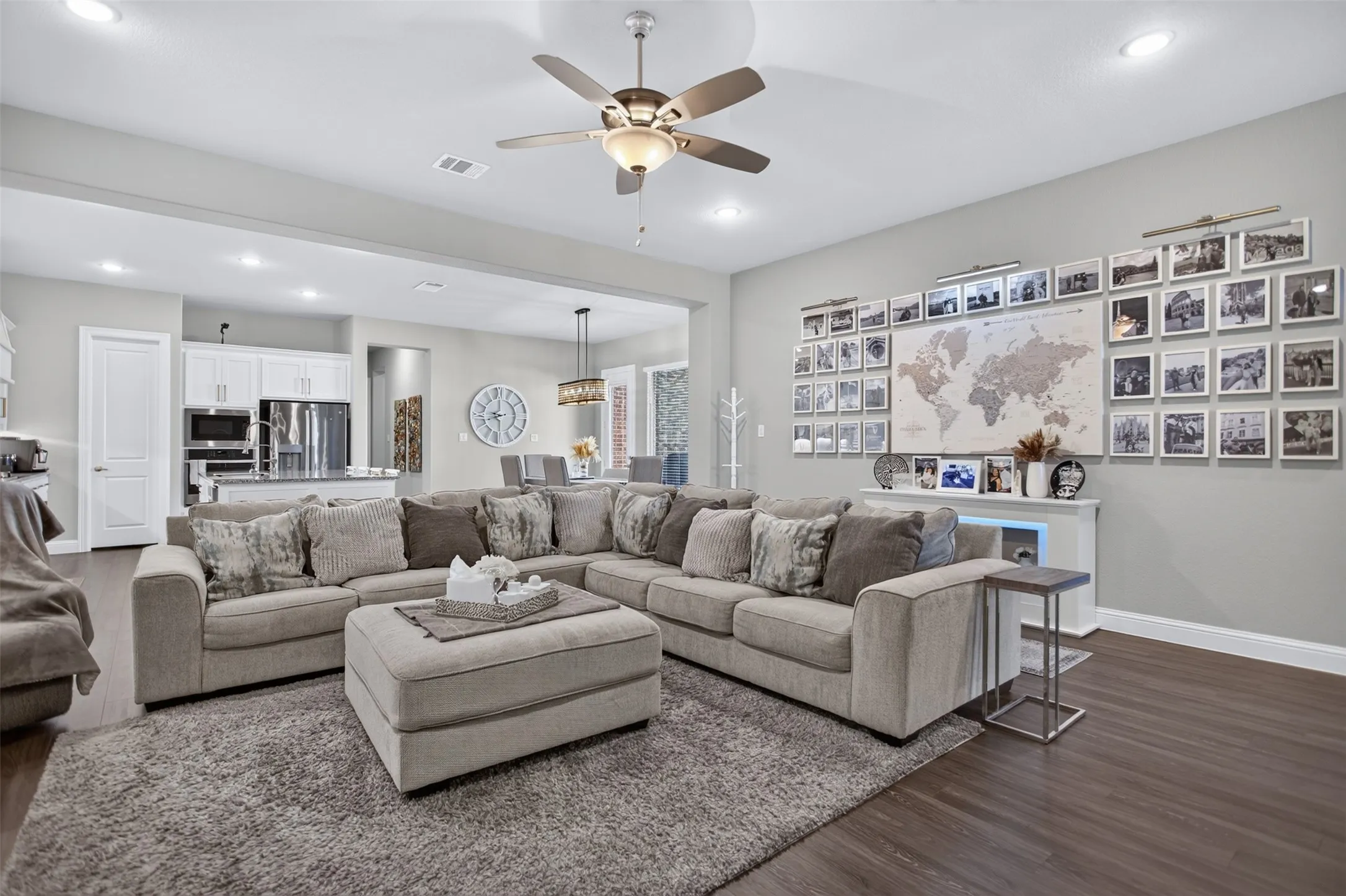 Open-concept living area with wood-finish flooring, recessed lighting, and a ceiling fan