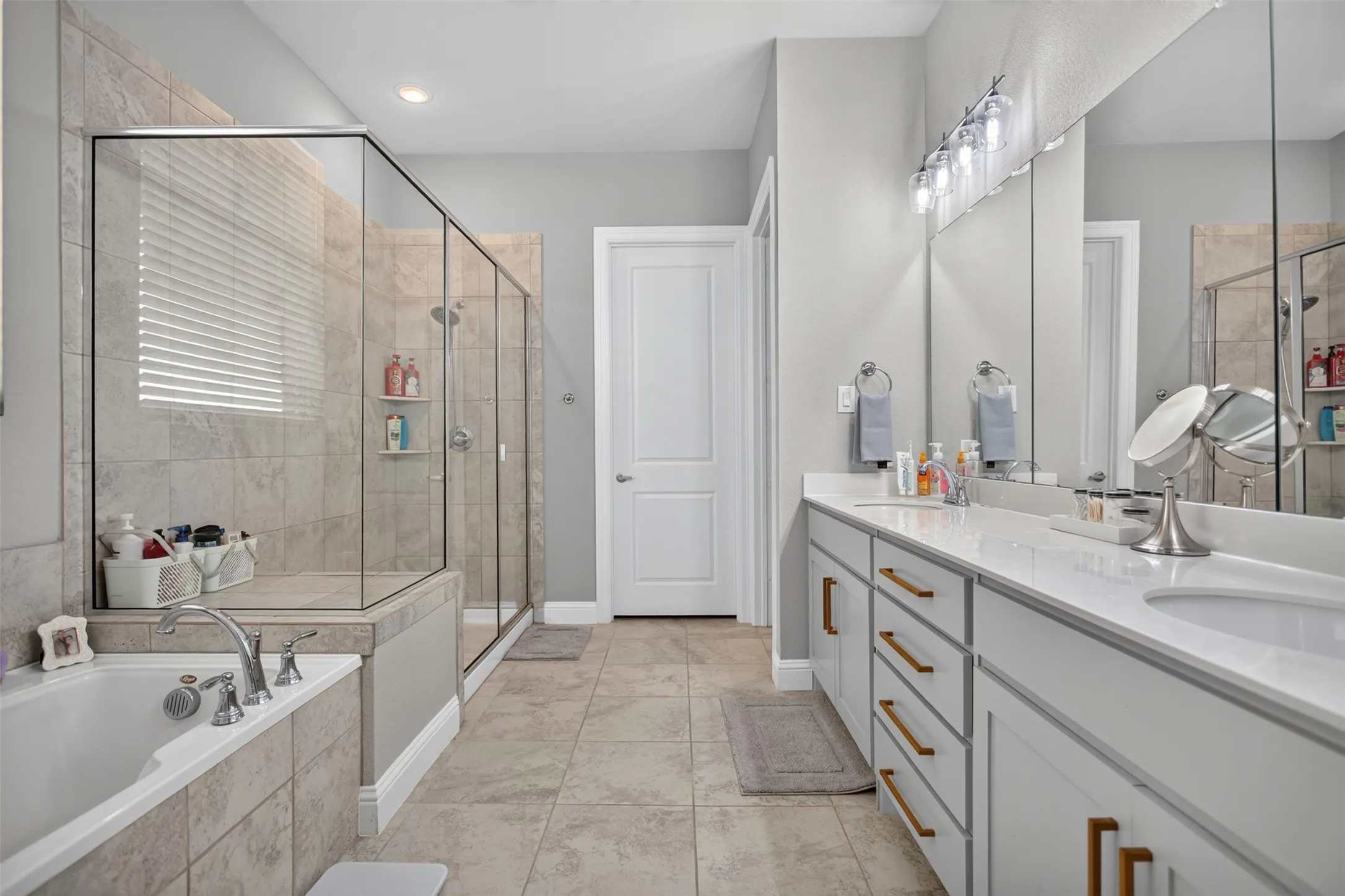 Dual vanity with undermount sinks, quartz countertops, and brushed brass hardware
