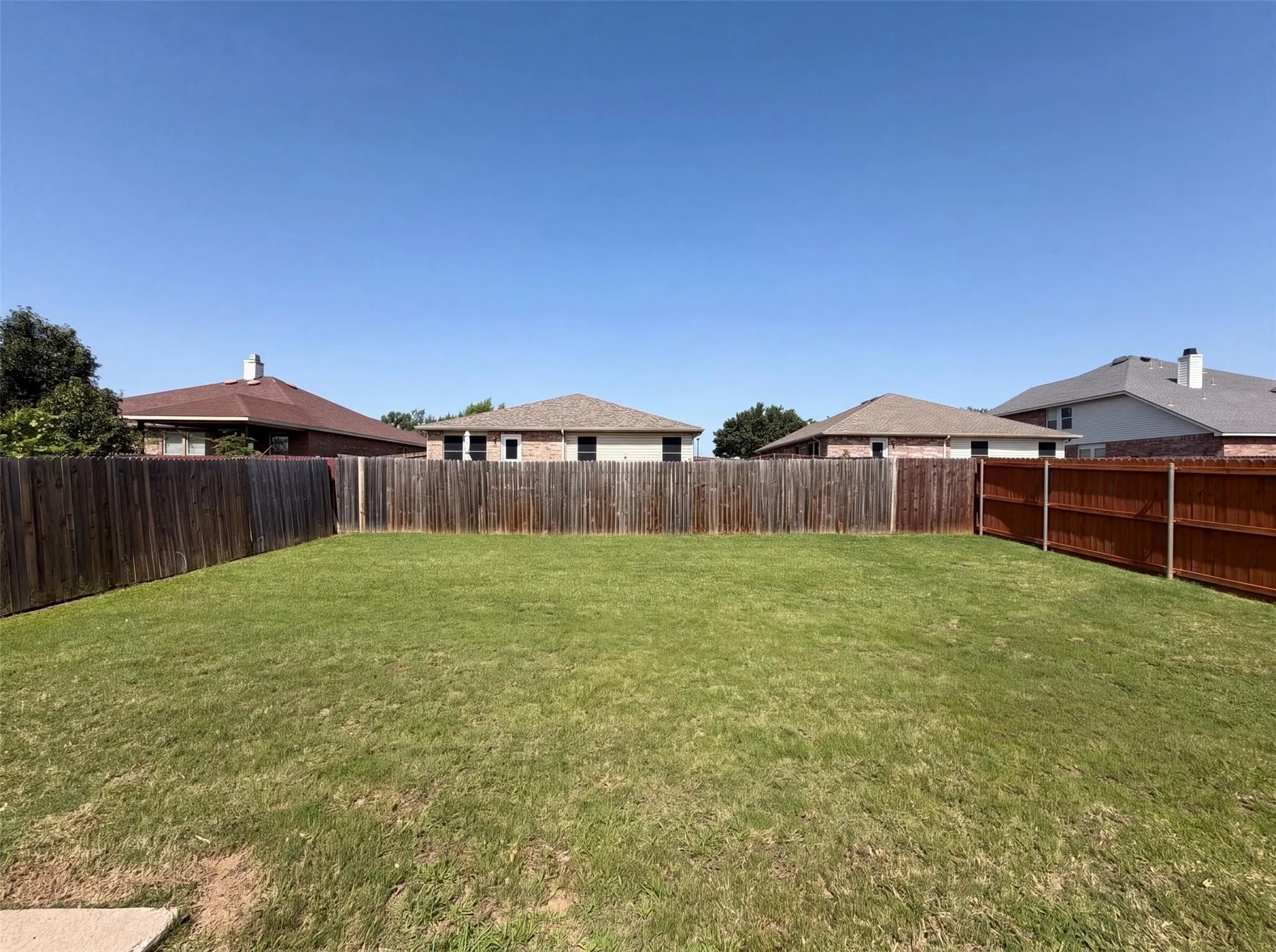 Expansive backyard with a lush lawn and a combination wood privacy fence