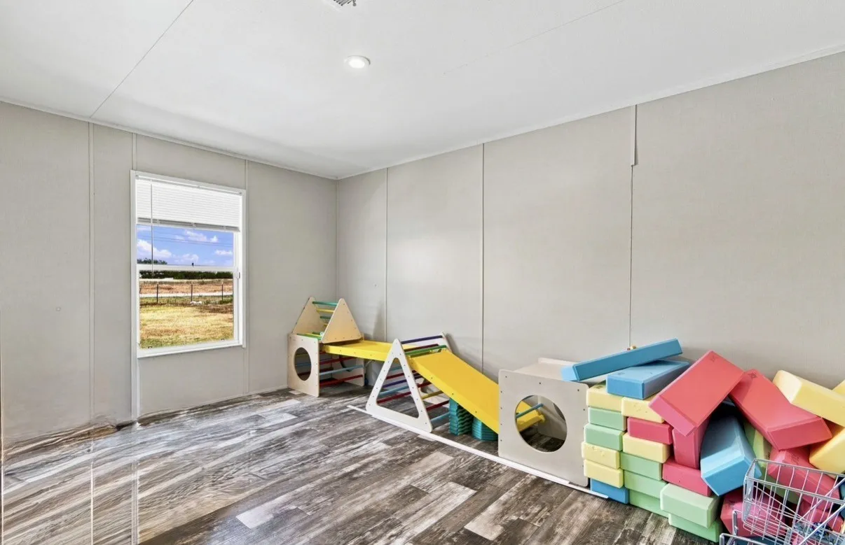 Recessed ceiling lighting, wood-finish flooring, and a window with blinds
