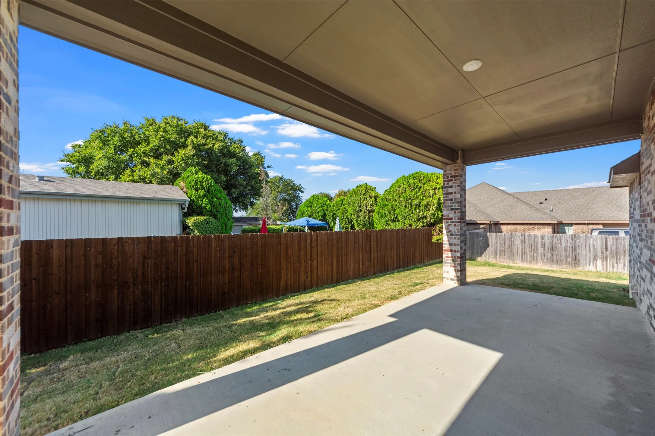 Covered patio with recessed lighting, brick columns, and concrete flooring