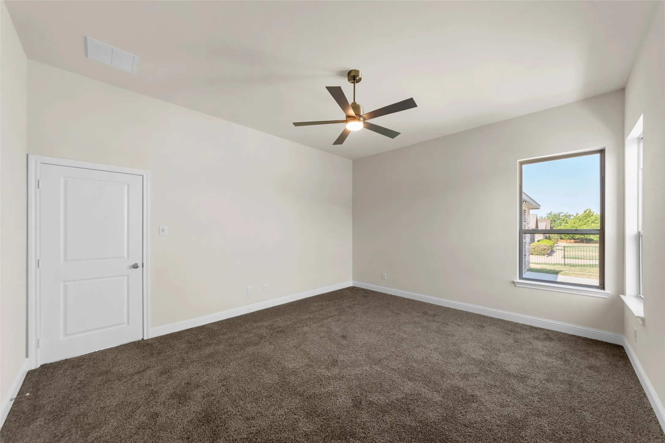 Spacious room featuring vaulted ceilings, a ceiling fan, and carpeted flooring