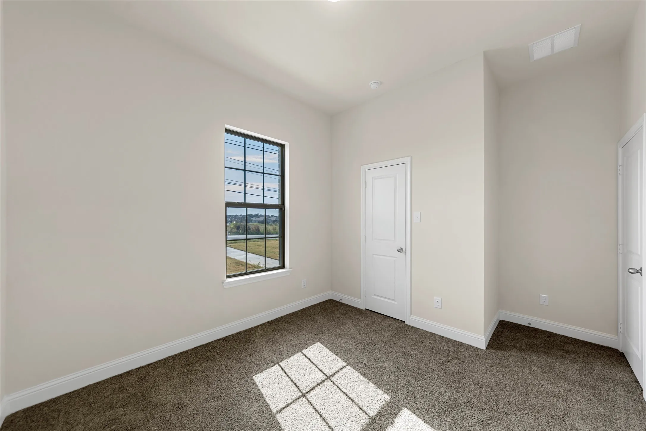 Neutral wall tones with carpet flooring, a multi-pane window, and recessed lighting