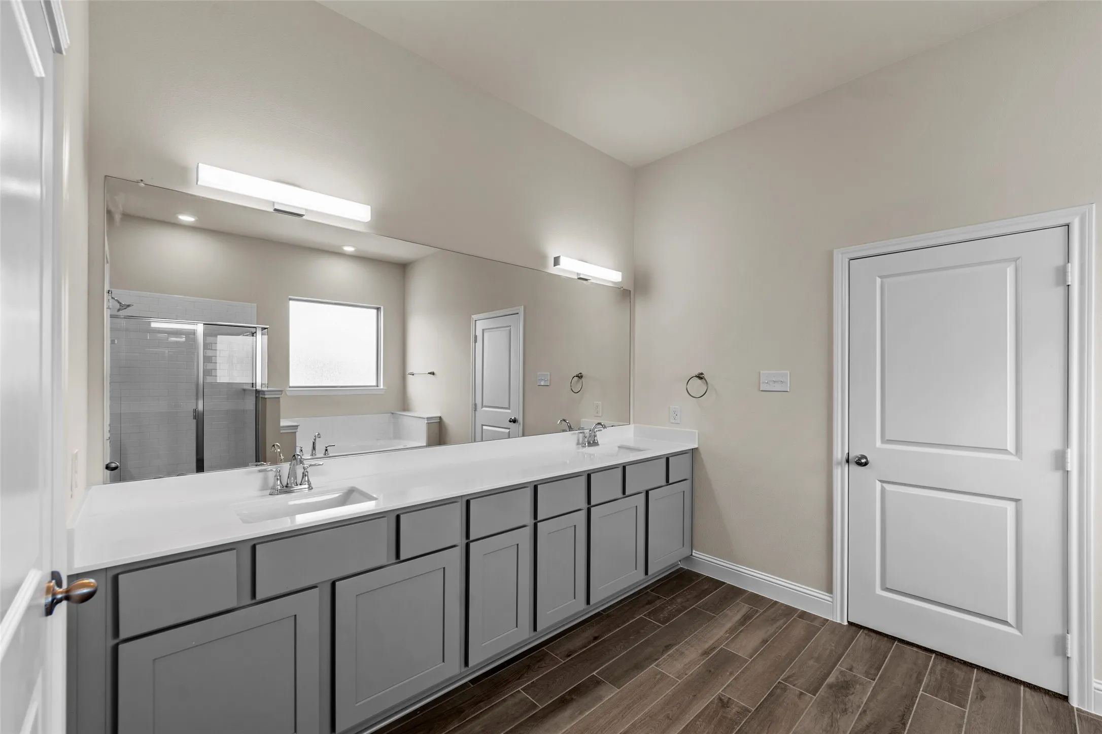 Dual vanity with gray shaker cabinetry and white countertops