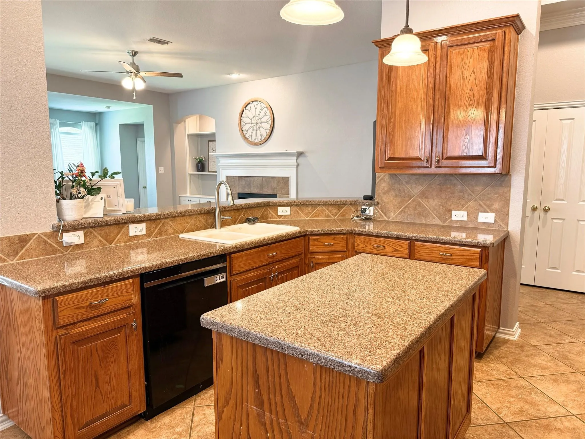 Kitchen featuring wood cabinetry, a center island with countertop, and an integrated double basin sink