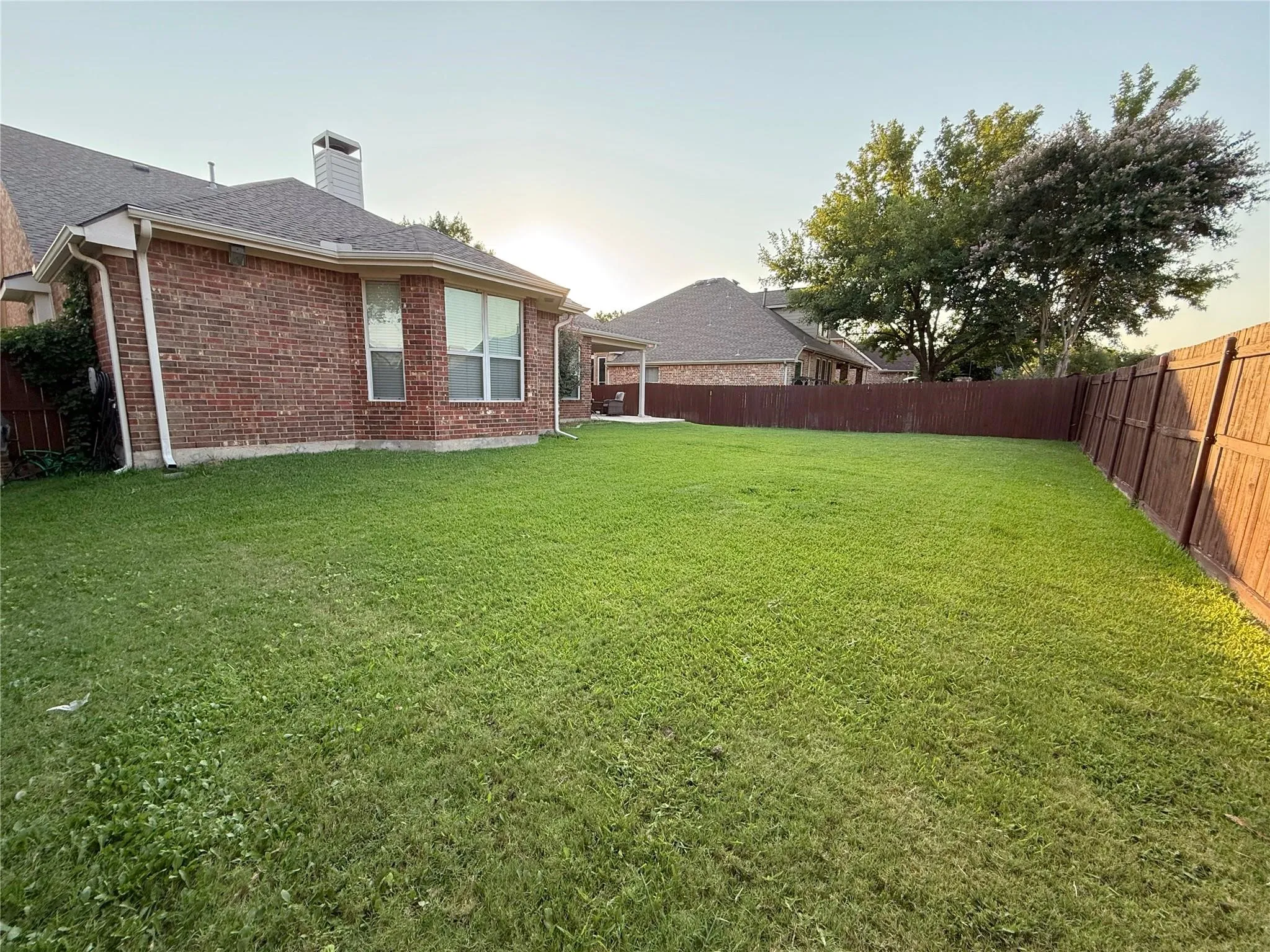 Expansive green lawn with a solid wood privacy​​‌​​​​‌​​‌‌​‌‌​​​‌‌​‌​‌​‌​​​‌​​ fence