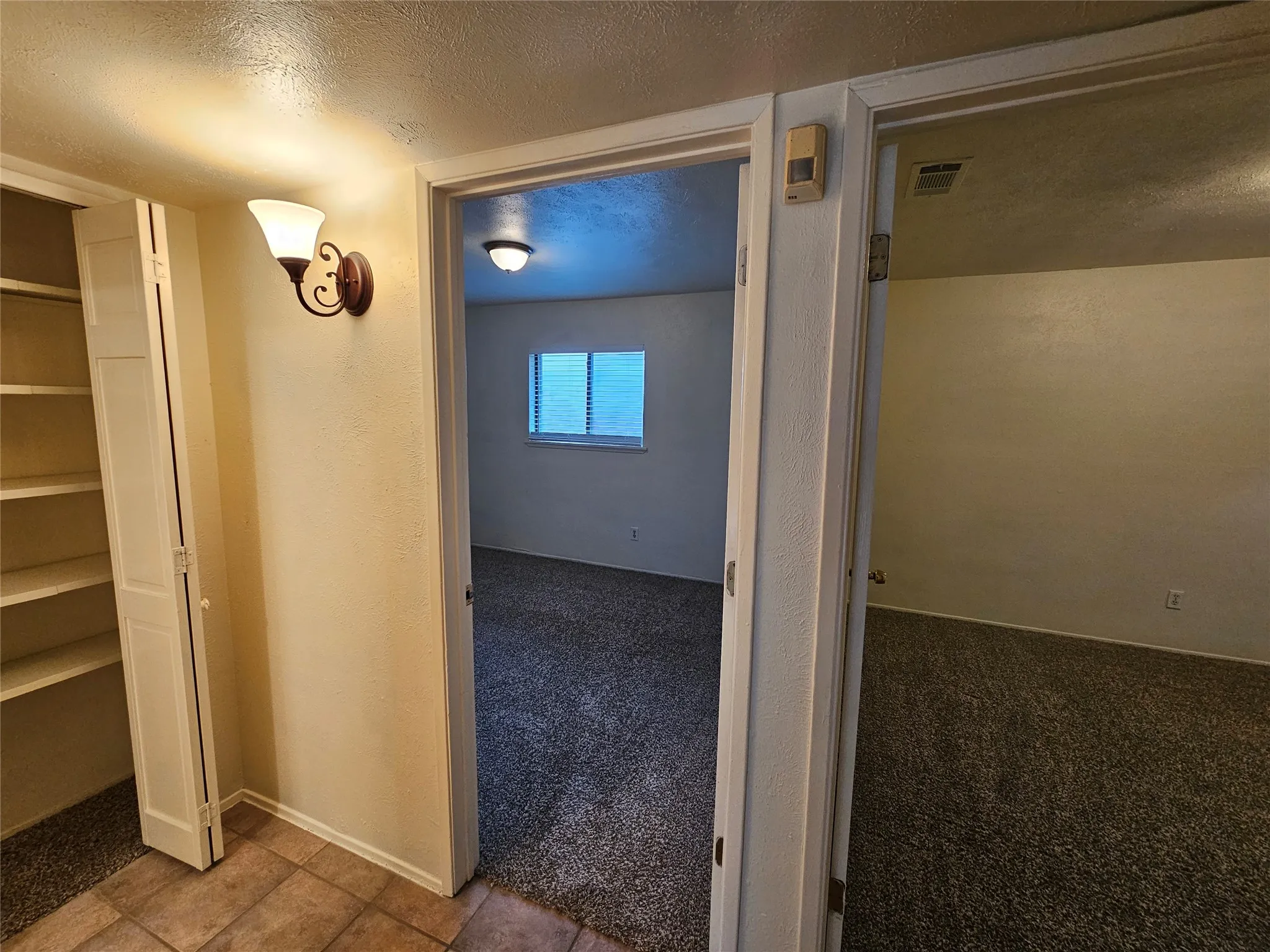 Built-in shelving, wall sconce lighting, and tile flooring