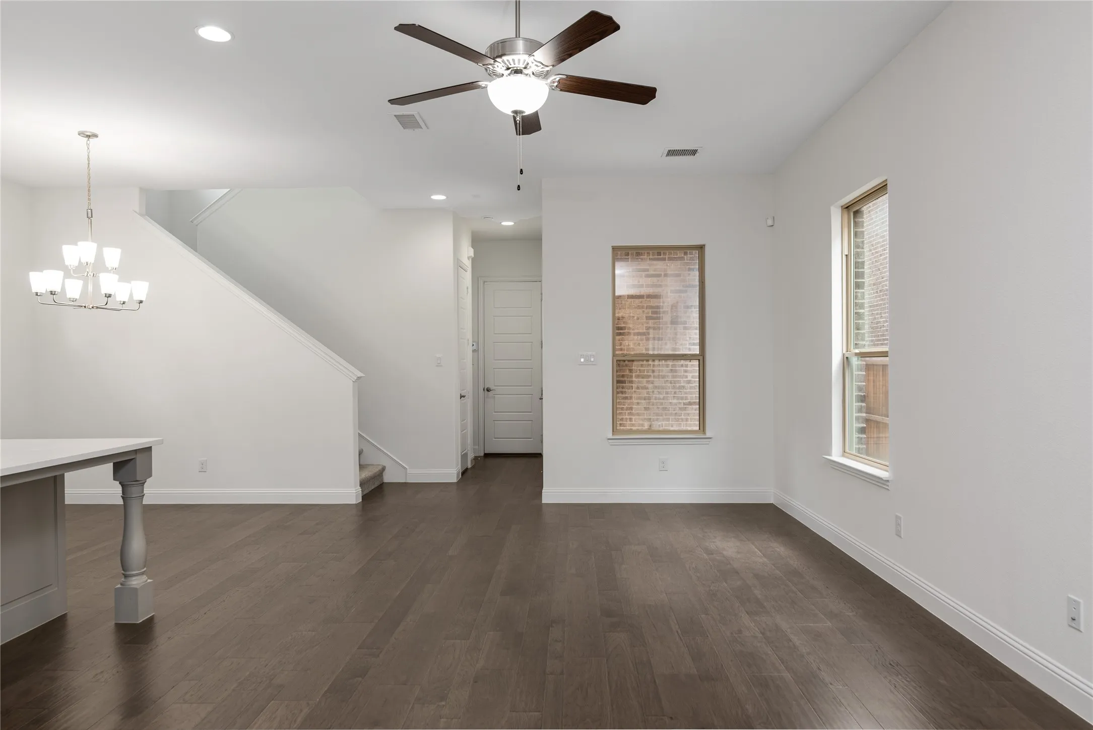 Open-concept living space with wood-finish flooring, recessed lighting, and a modern ceiling fan